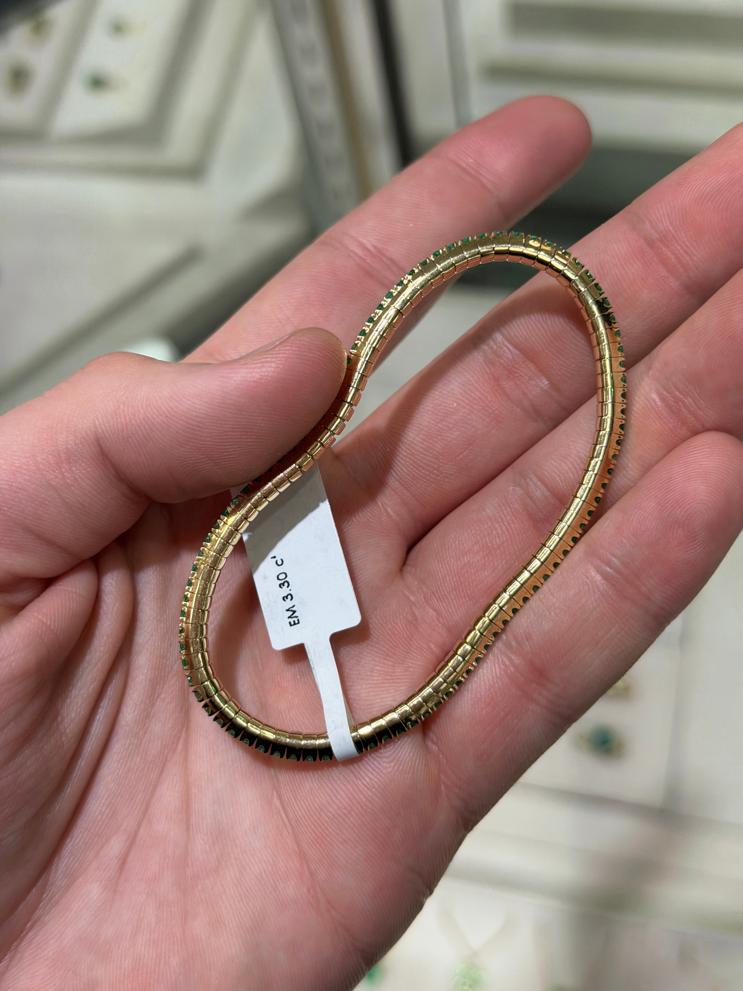 14K gold tennis bracelet with round emeralds totaling 3.30tcw, featuring a stretchy design and natural Colombian emeralds.