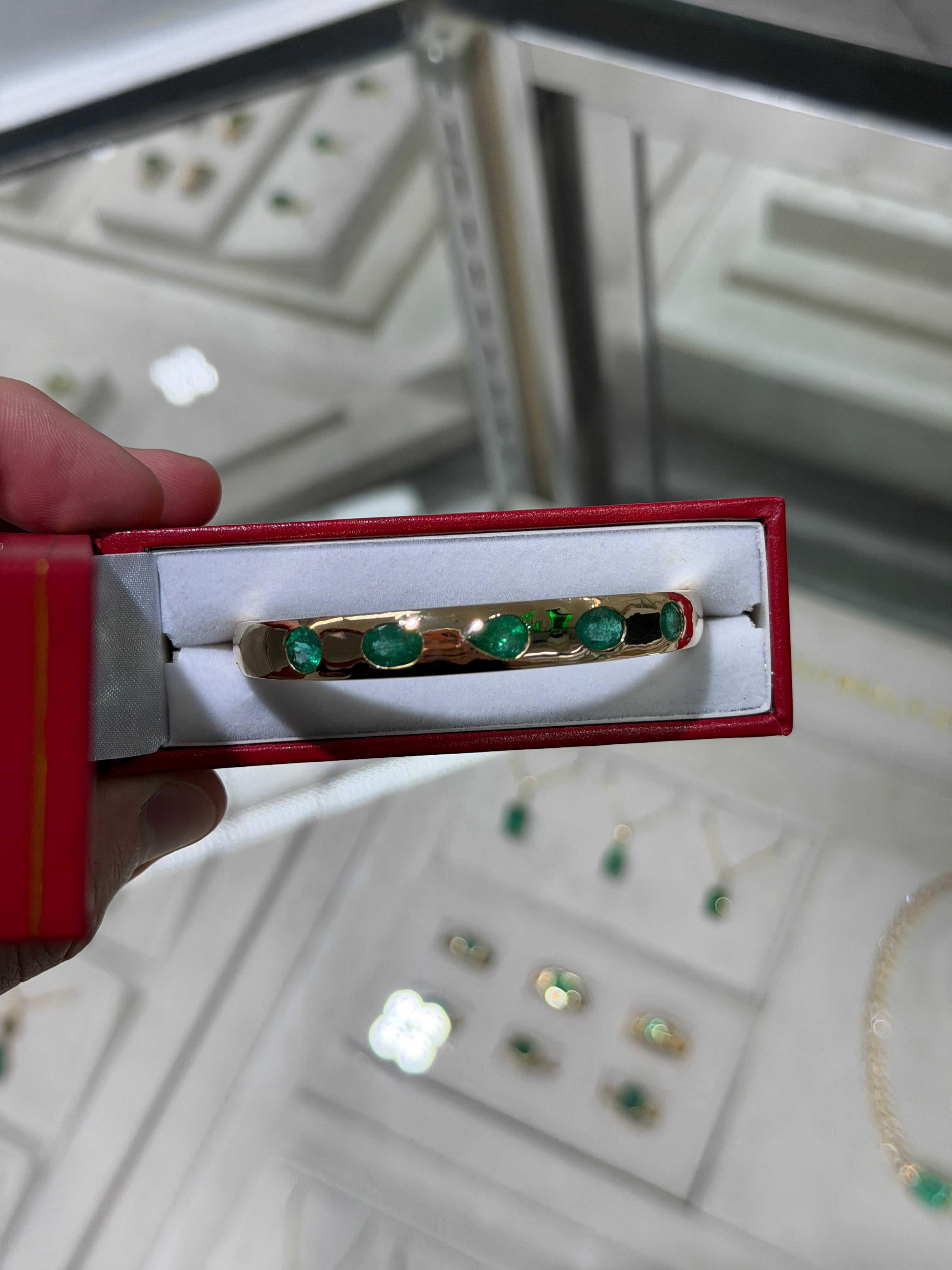 14K gold emerald bangle bracelet featuring 5.66tcw natural rich green pear and oval cut emeralds bezel set by JR Colombian Emeralds.