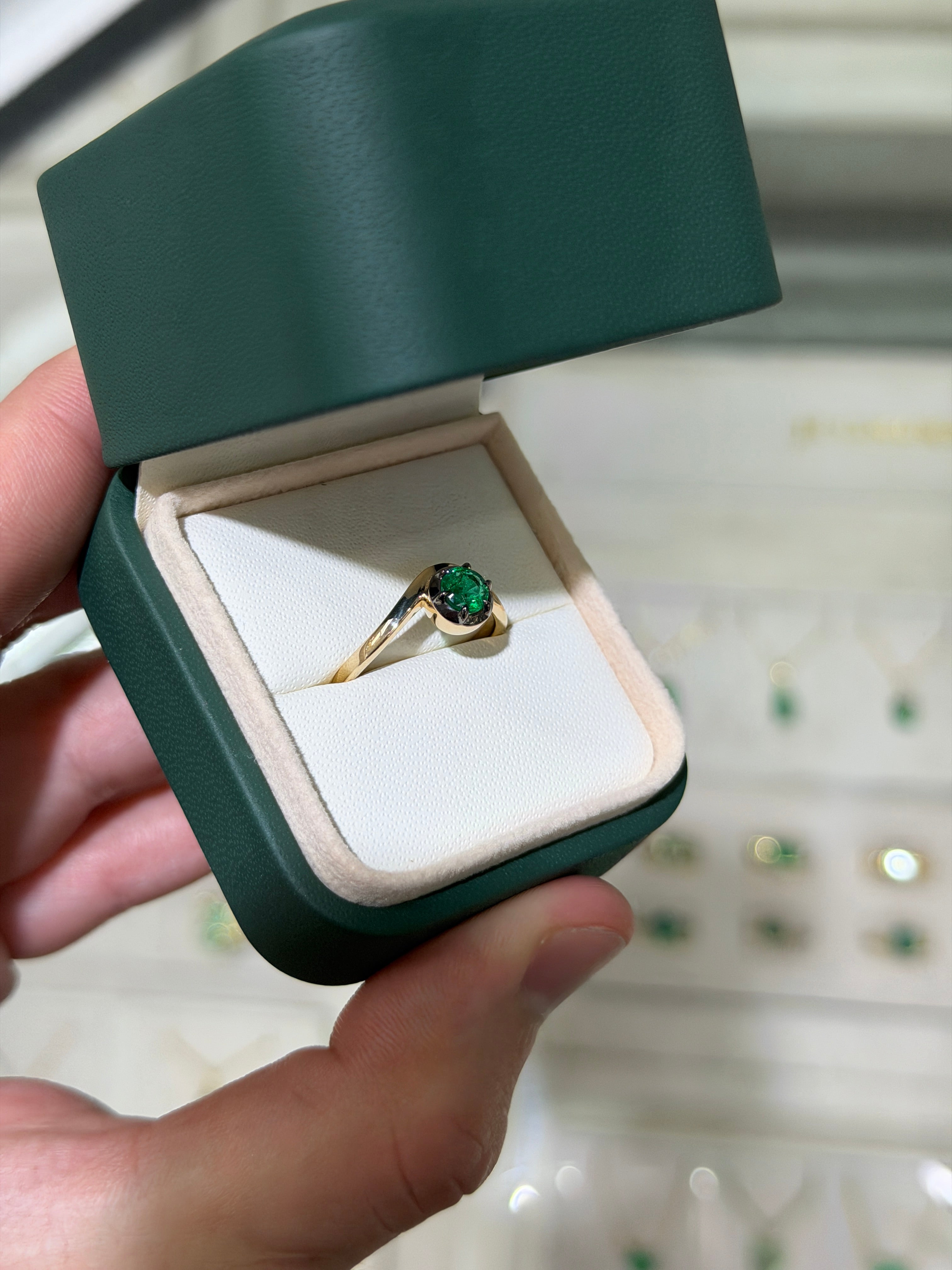 14K gold ladies emerald ring featuring a 0.64ct round cut emerald solitaire with black rhodium finish, multi-prong setting by JR Colombian Emeralds.