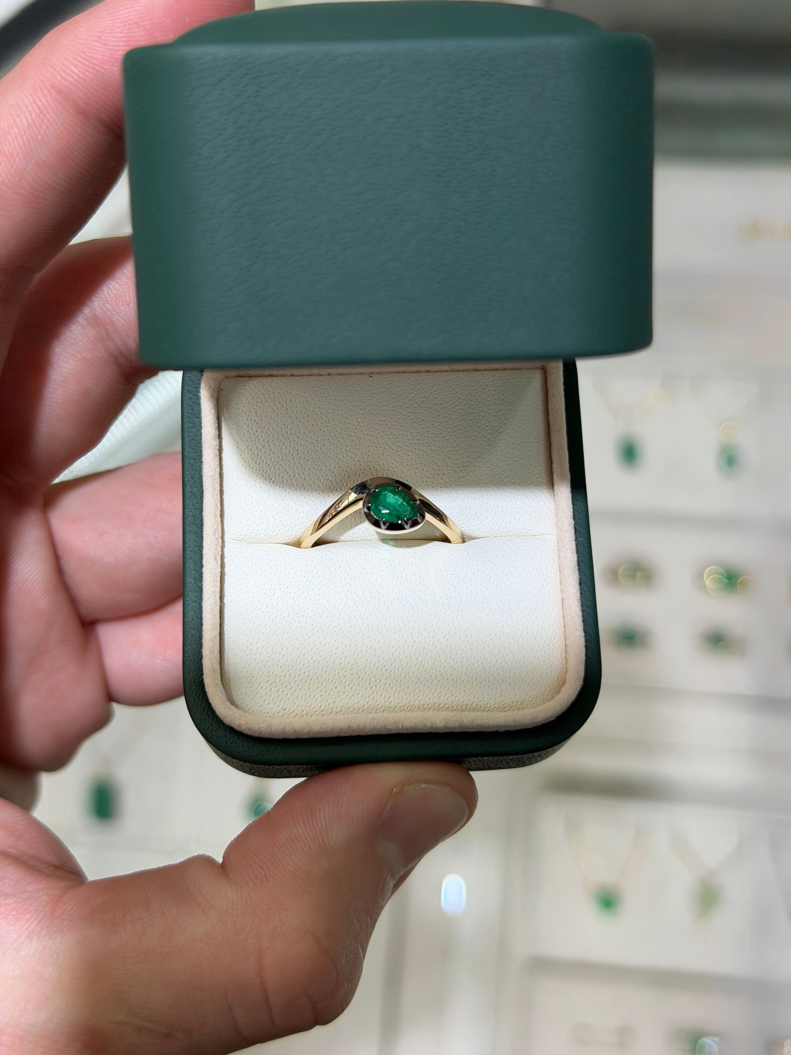 14K gold emerald solitaire ring with a pear-shaped green emerald and black rhodium finish, featuring a 0.46ct center stone.
