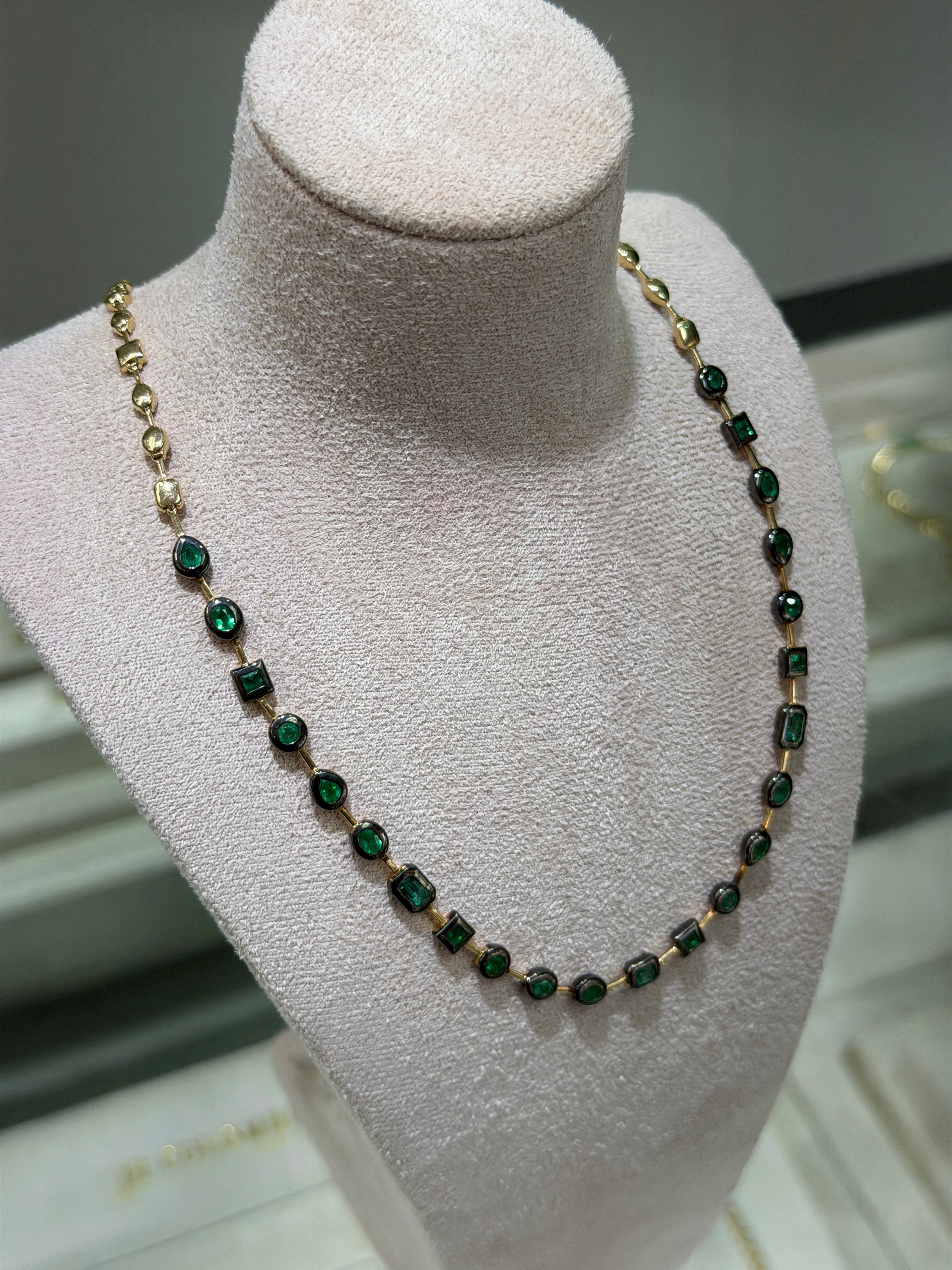 14K gold emerald tennis necklace with black rhodium, featuring mixed cut emeralds and bezel setting, 18-inch length by JR Colombian Emeralds.