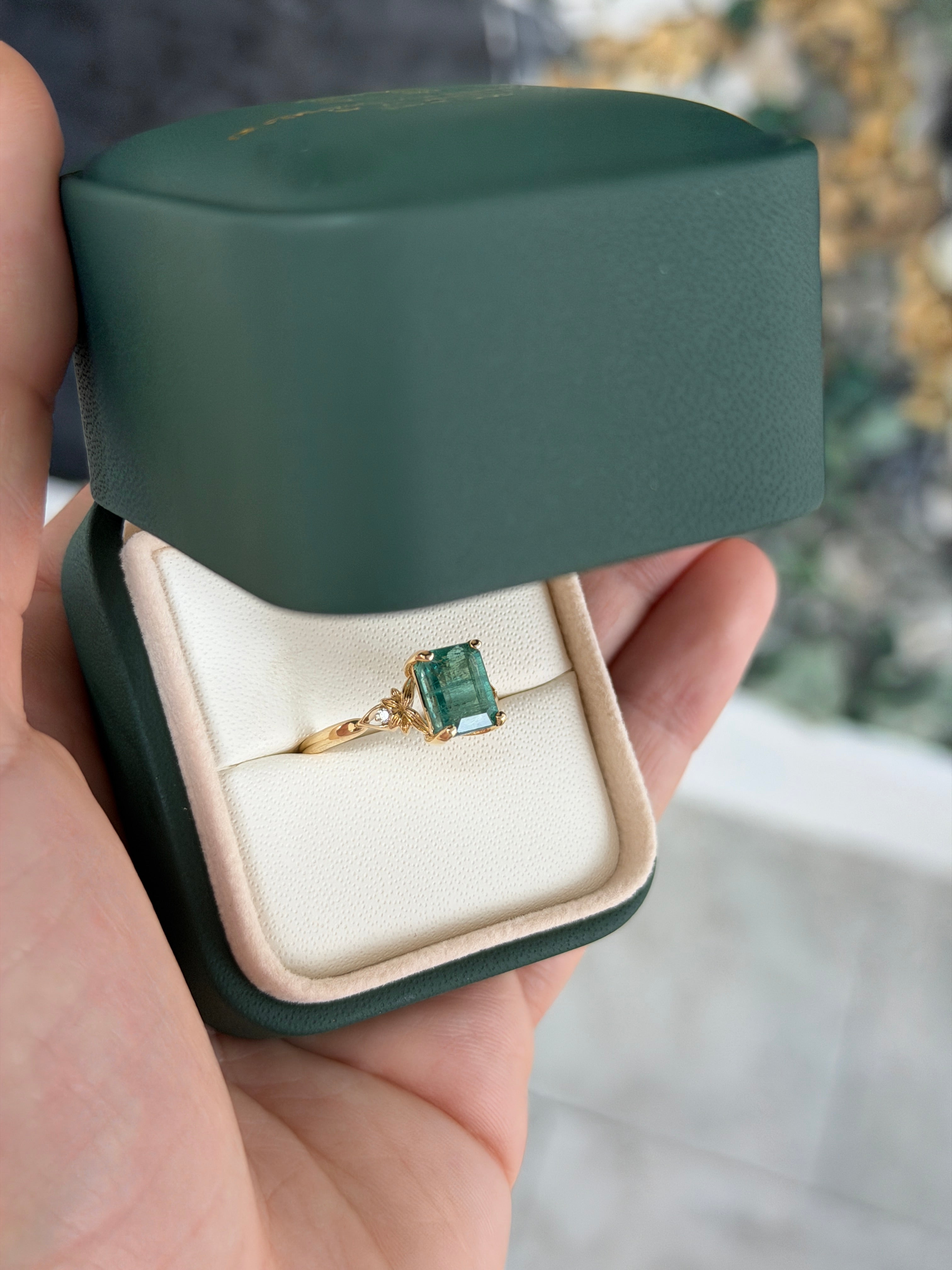 Anello solitario in oro 14 carati con smeraldo, impreziosito da diamanti sintetici per un totale di 2,30 carati, caratterizzato da una gemma centrale di smeraldo e da dettagli raffinati.