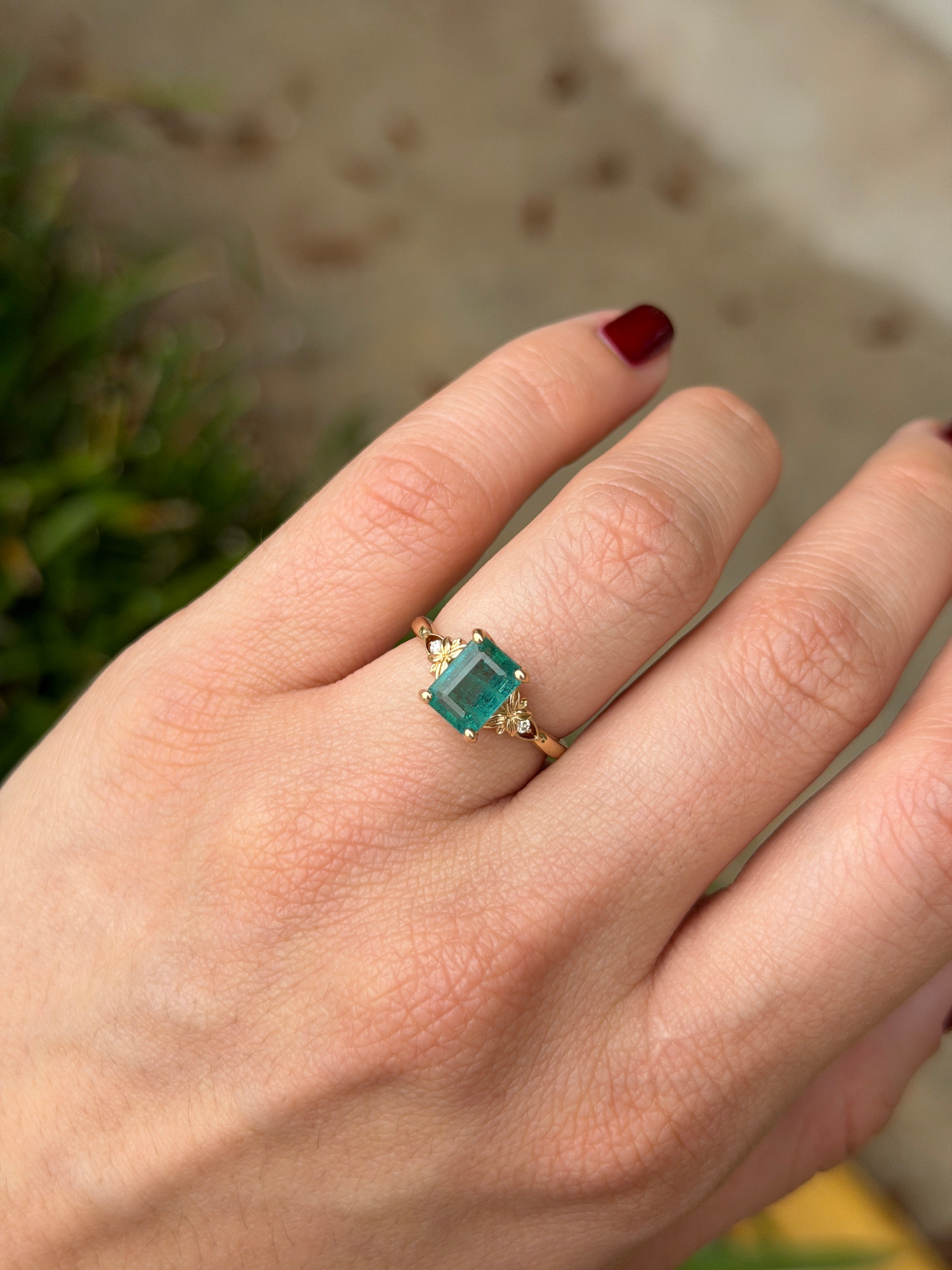 Anello solitario in oro 14 carati con smeraldo del peso complessivo di 2,30 carati e diamanti sintetici a fare da contorno, caratterizzato da uno smeraldo centrale.