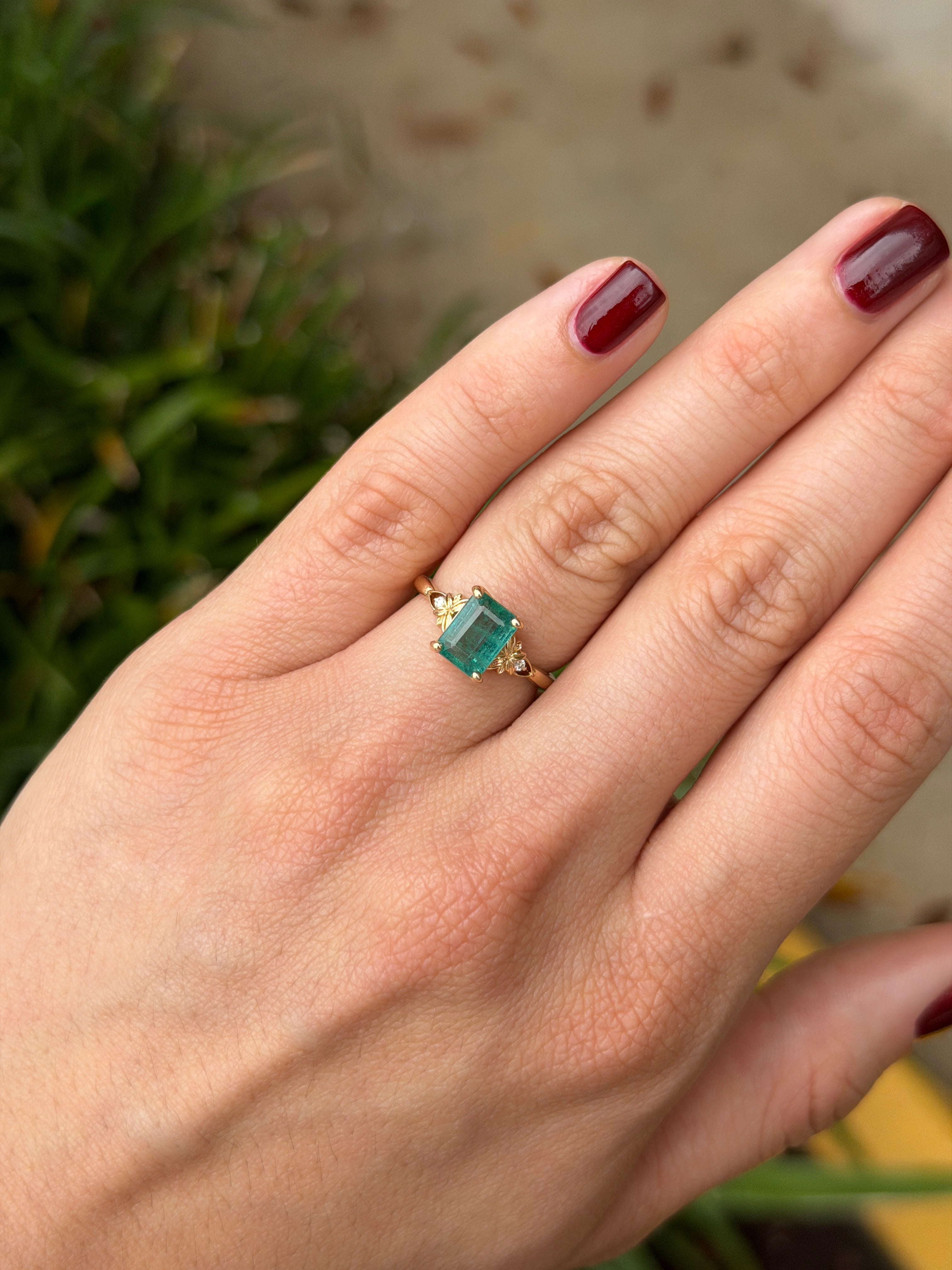 Anello solitario in oro 14 carati con smeraldo, impreziosito da diamanti sintetici per un totale di 2,30 carati, caratterizzato da una gemma centrale a forma di smeraldo e da dettagli raffinati.