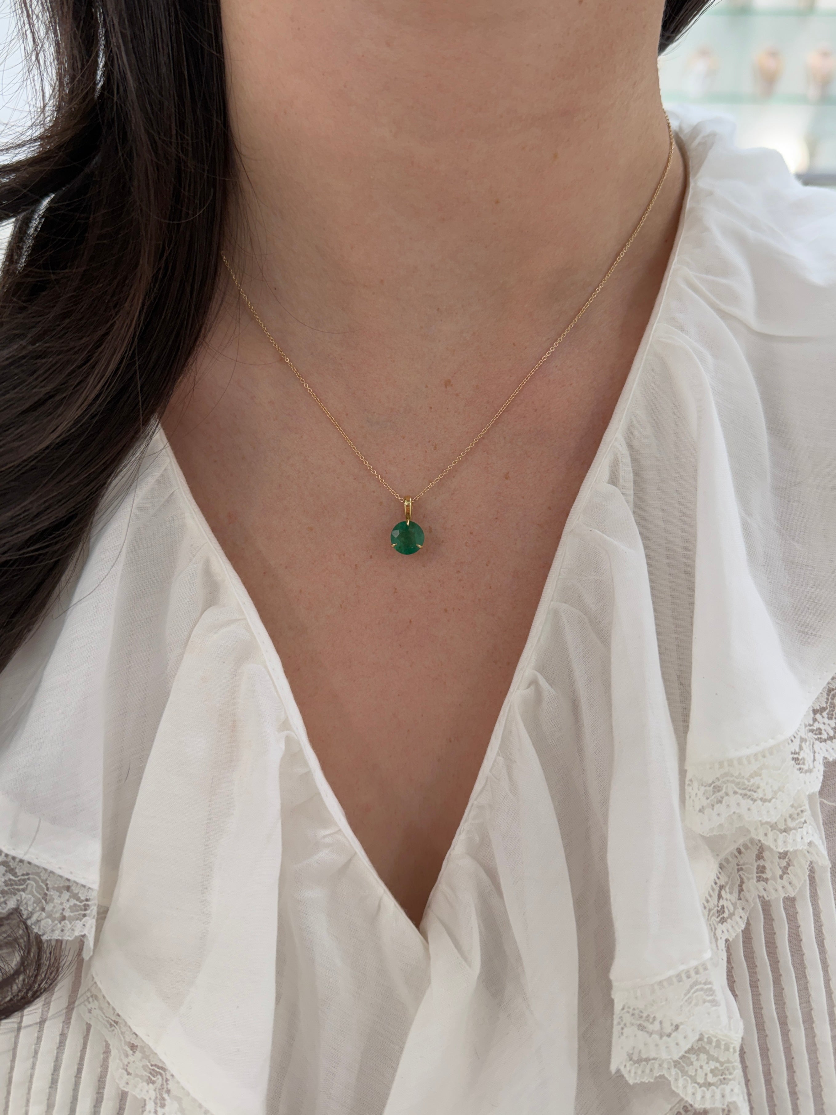 14K gold emerald solitaire necklace featuring a 1.66ct round emerald in a three-prong setting by JR Colombian Emeralds.