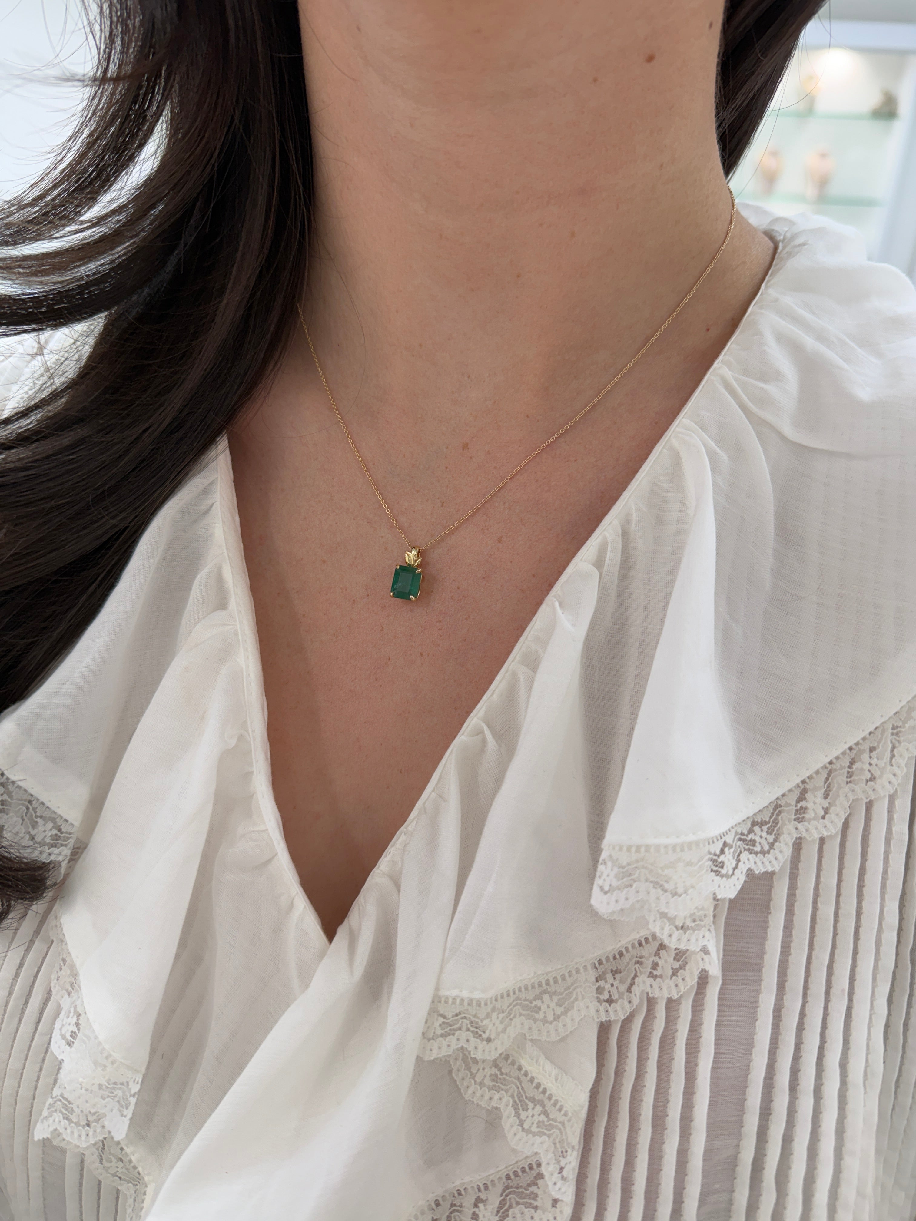 Emerald cut emerald pendant with leaf design and 14K gold bail, showcasing a 2.52 carat natural emerald necklace by JR Colombian Emeralds.