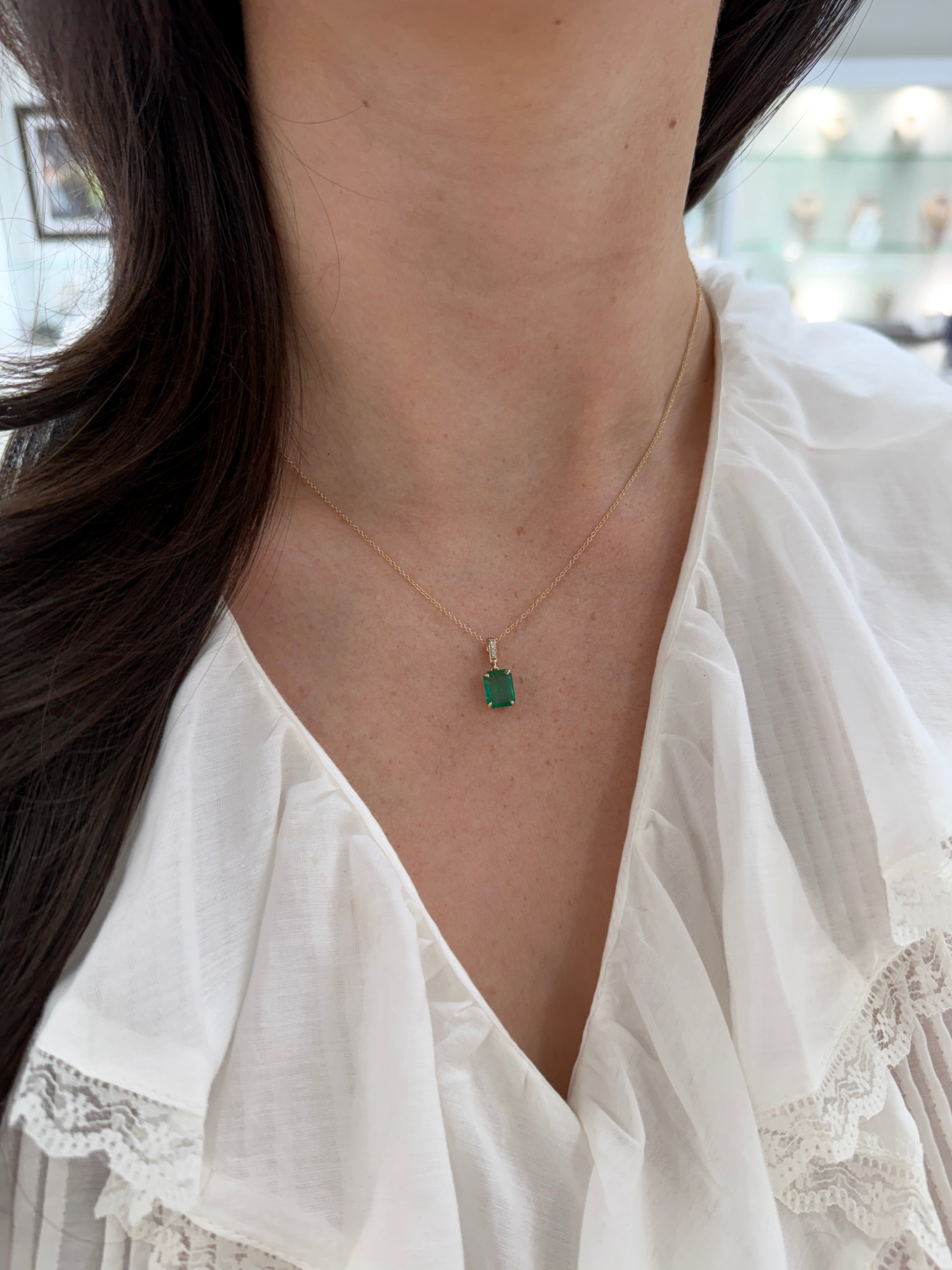 Emerald cut emerald pendant with diamond bail in 14K gold, featuring 1.79 carats from JR Colombian Emeralds.
