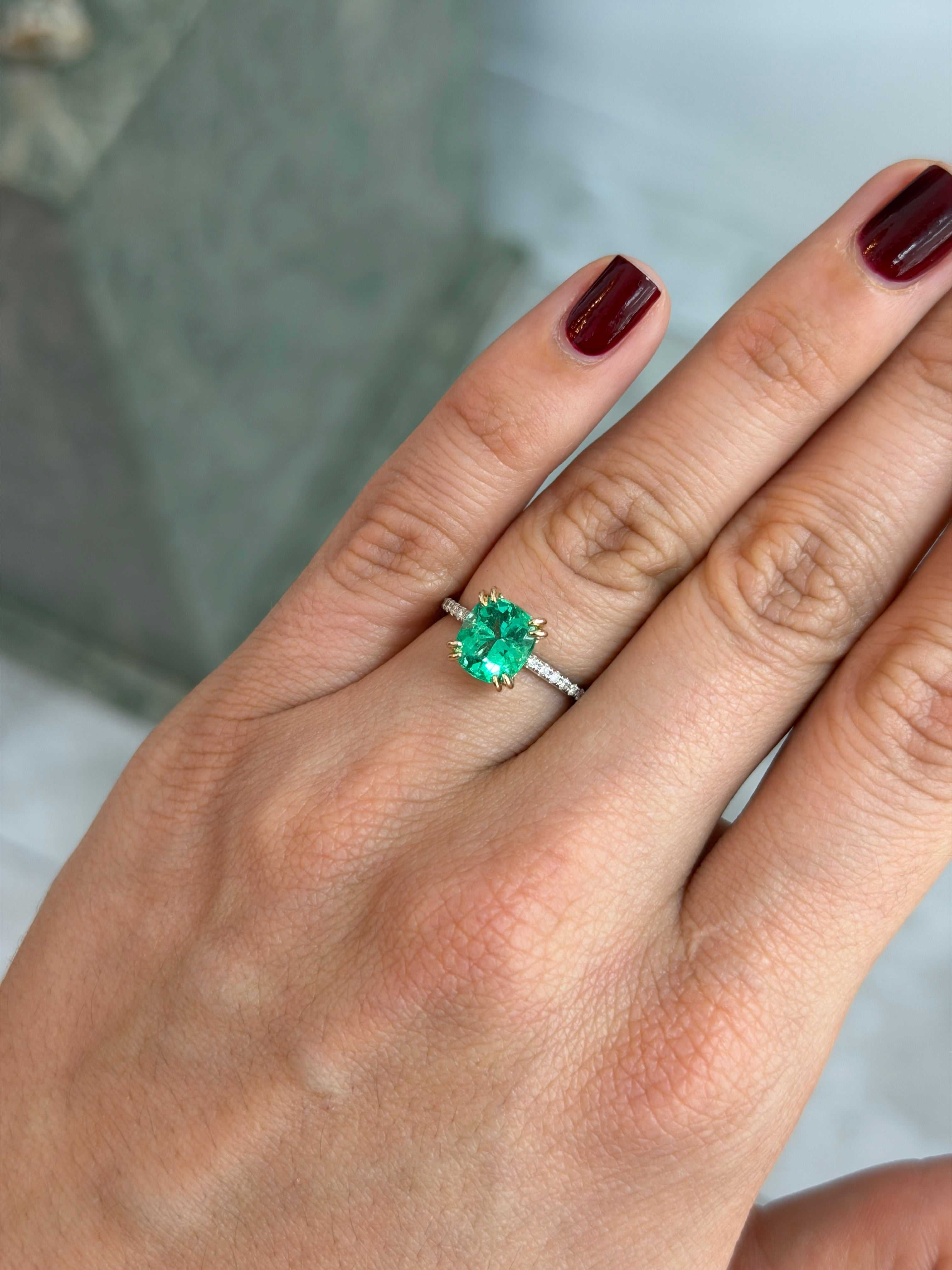 14K engagement ring with 2.58 carat cushion-cut natural emerald and diamond accents, featuring a detailed gold band.