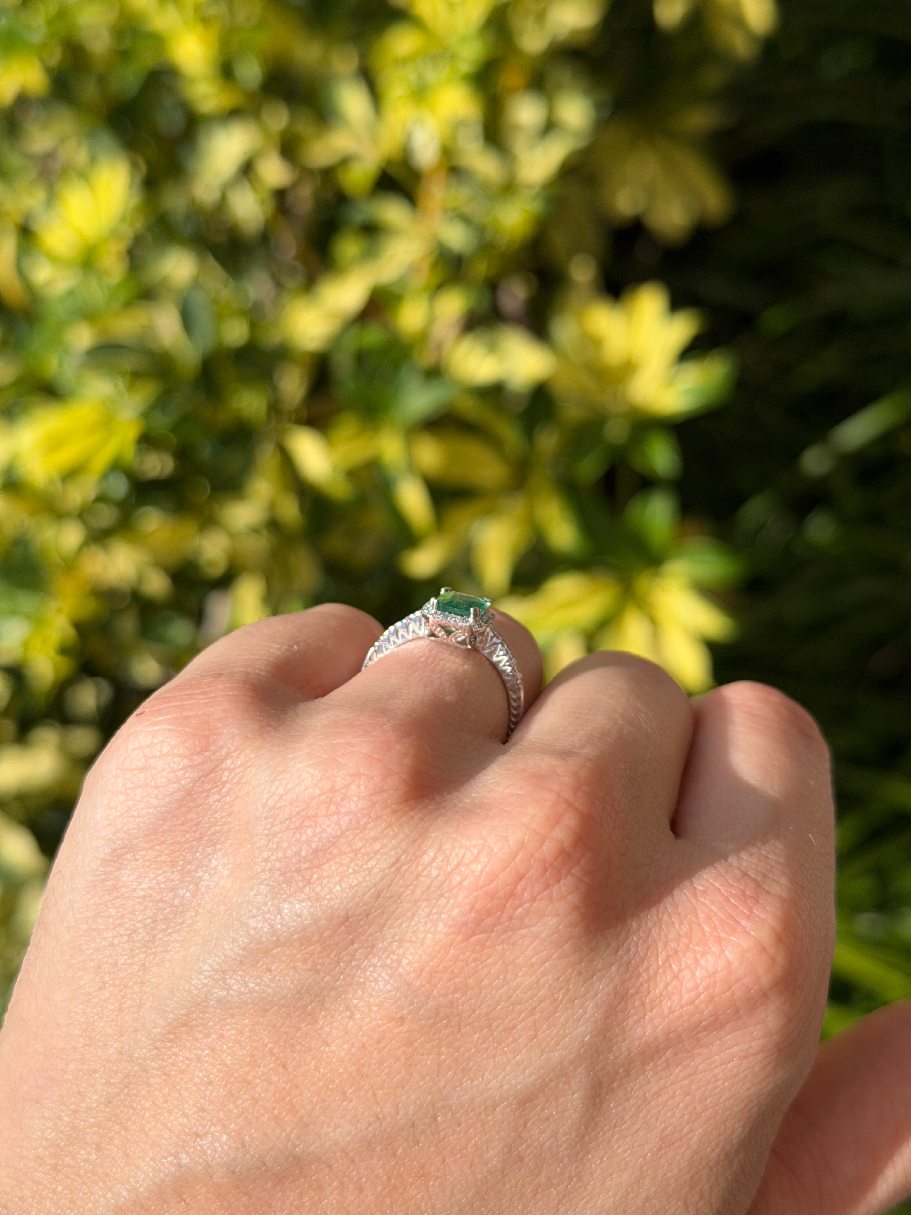 10x7.5mm emerald and diamond halo engagement ring in 14K white gold by JR Colombian Emeralds, featuring a clear crystal design