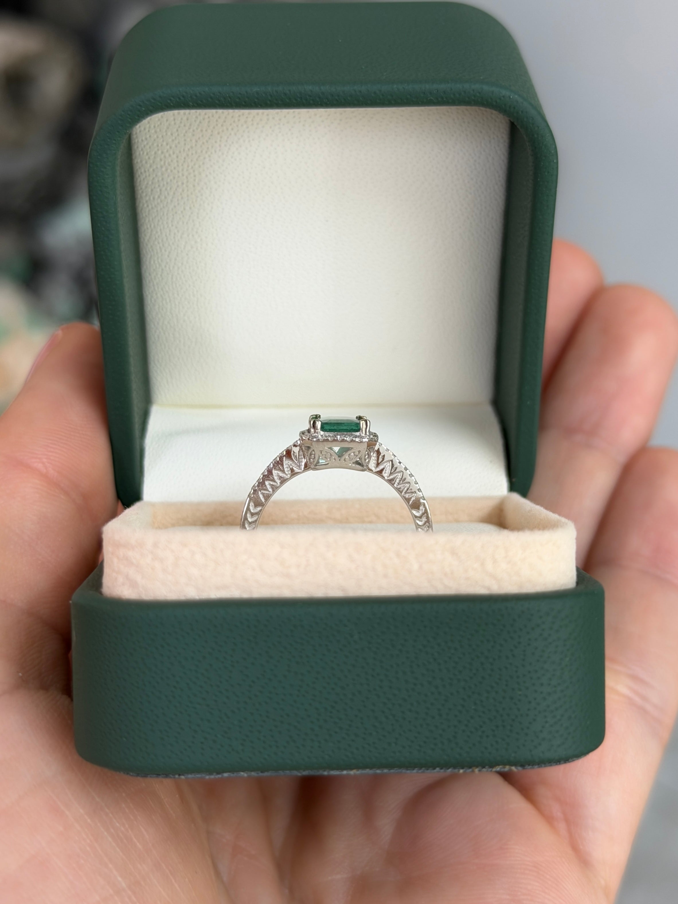10x7.5mm emerald and diamond halo engagement ring in 14K white gold by JR Colombian Emeralds, featuring a clear crystal centerpiece.
