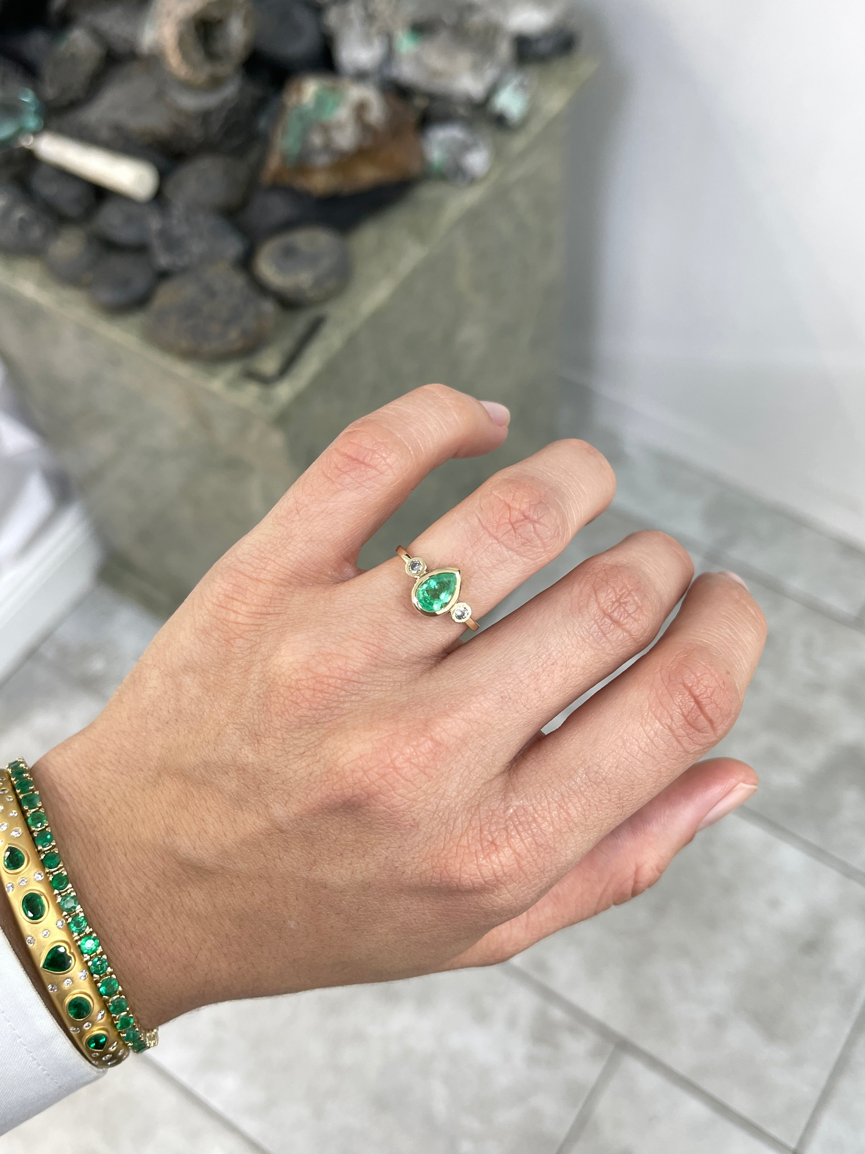 Bezel set tear drop natural emerald and diamond engagement ring with 14k gold, featuring three-stone design by JR Colombian Emeralds