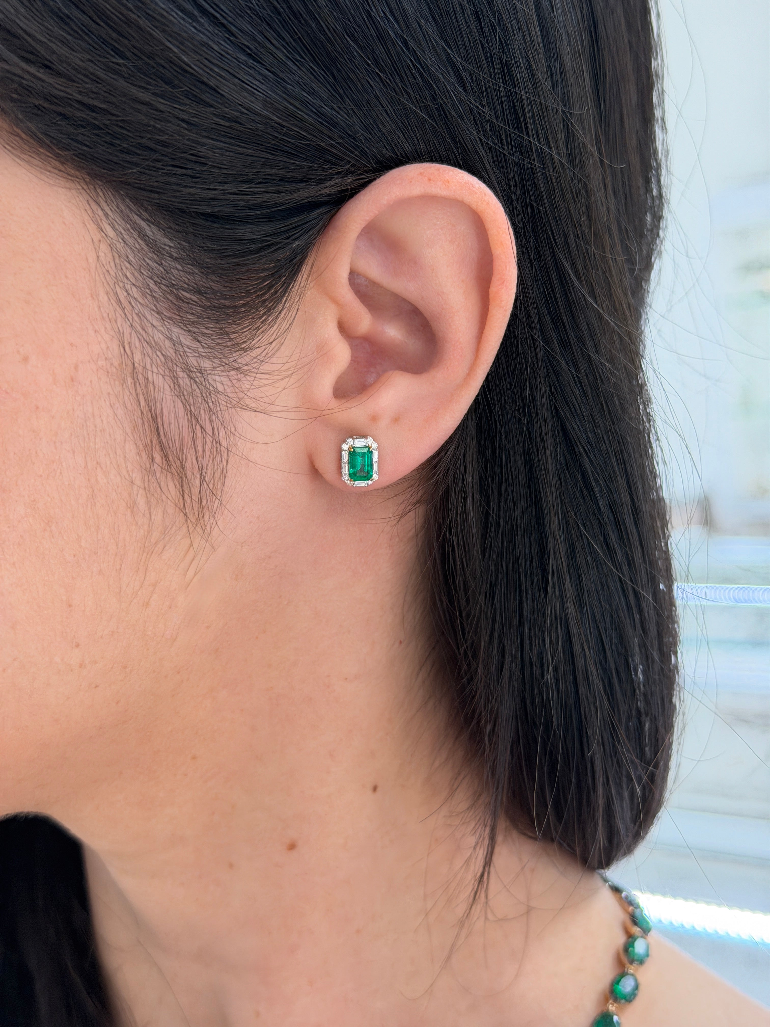 Emerald and baguette diamond halo stud earrings by JR Colombian Emeralds, 18K two-toned gold, with natural green emeralds and sparkling diamonds
