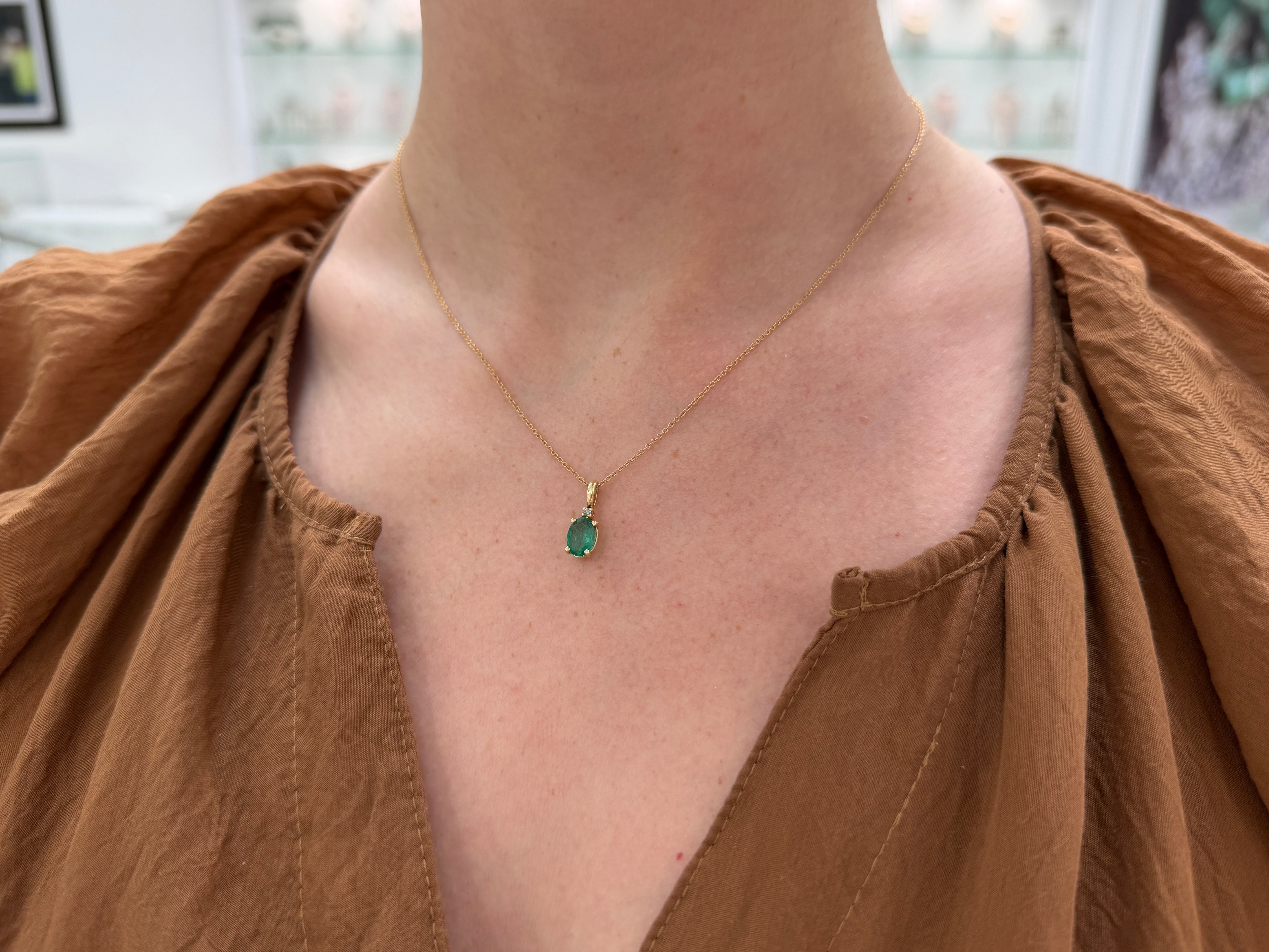 14K yellow gold pendant necklace featuring a 1.30ctw oval cut natural emerald with diamond accents, by JR Colombian Emeralds.