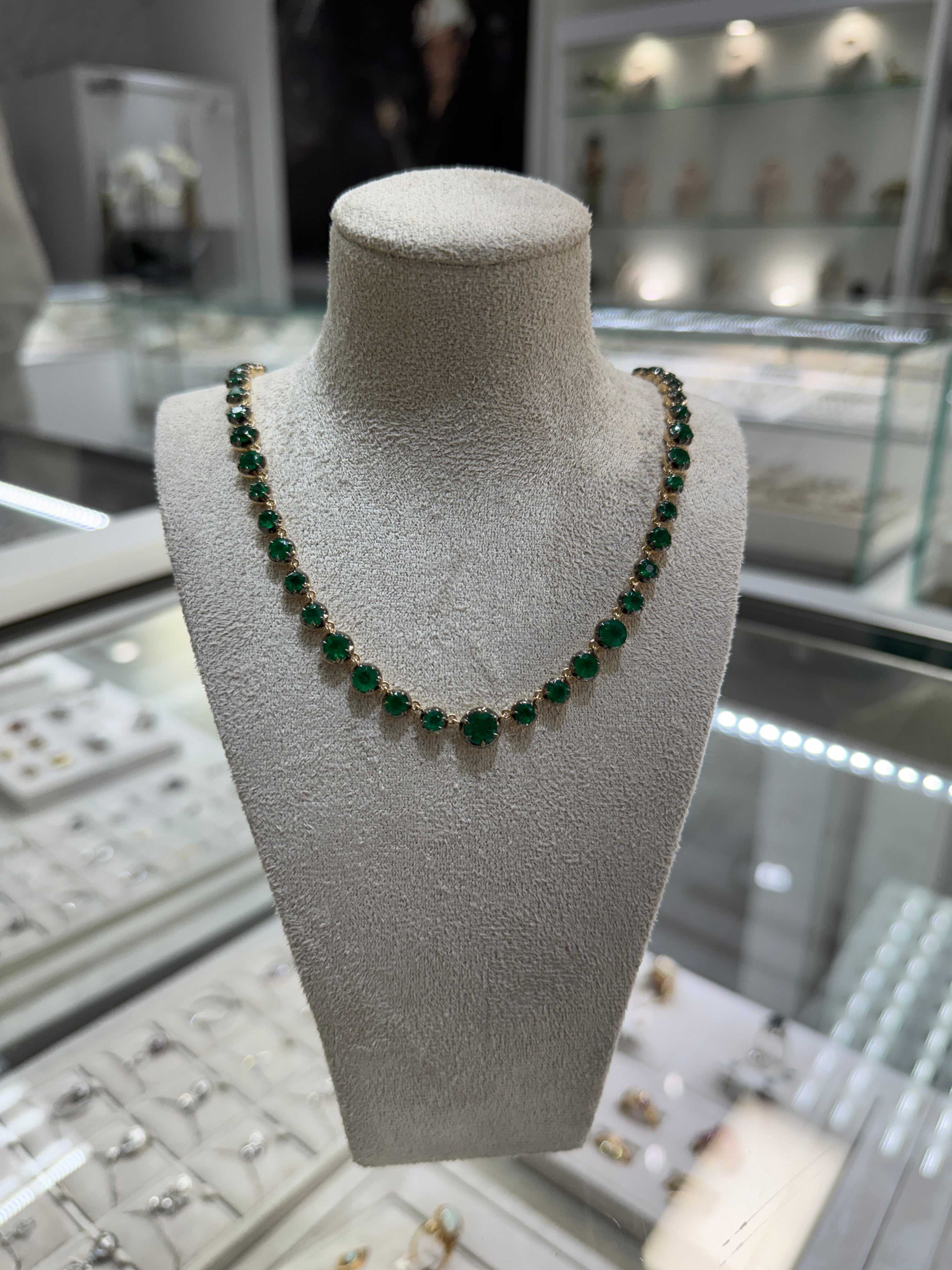 15.38tcw round emerald tennis necklace in 14K yellow gold on display bust