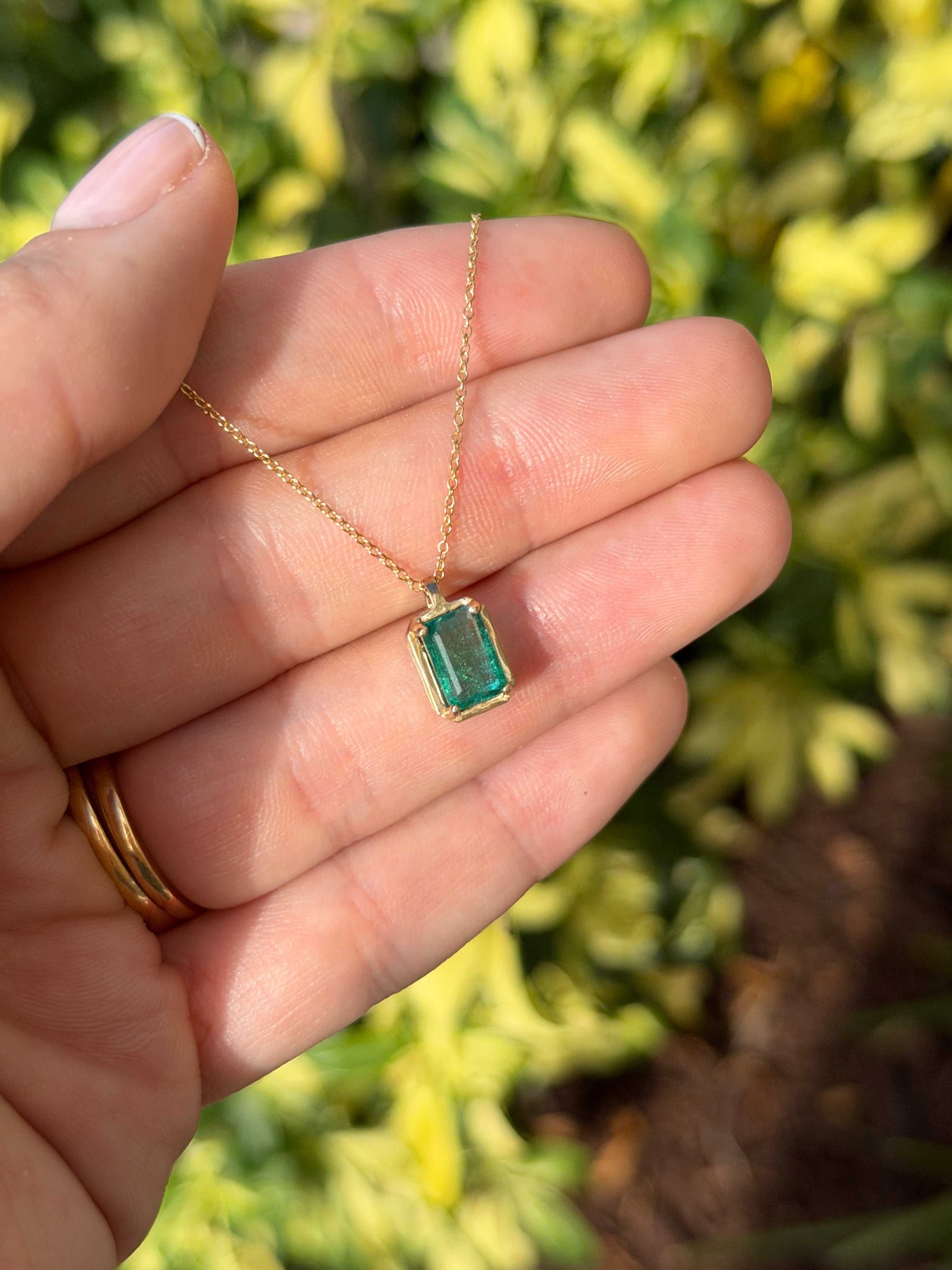 1.59 carat bluish green solitaire emerald necklace with 14K gold setting from JR Colombian Emeralds, featuring a sparkling crystal-clear emerald.