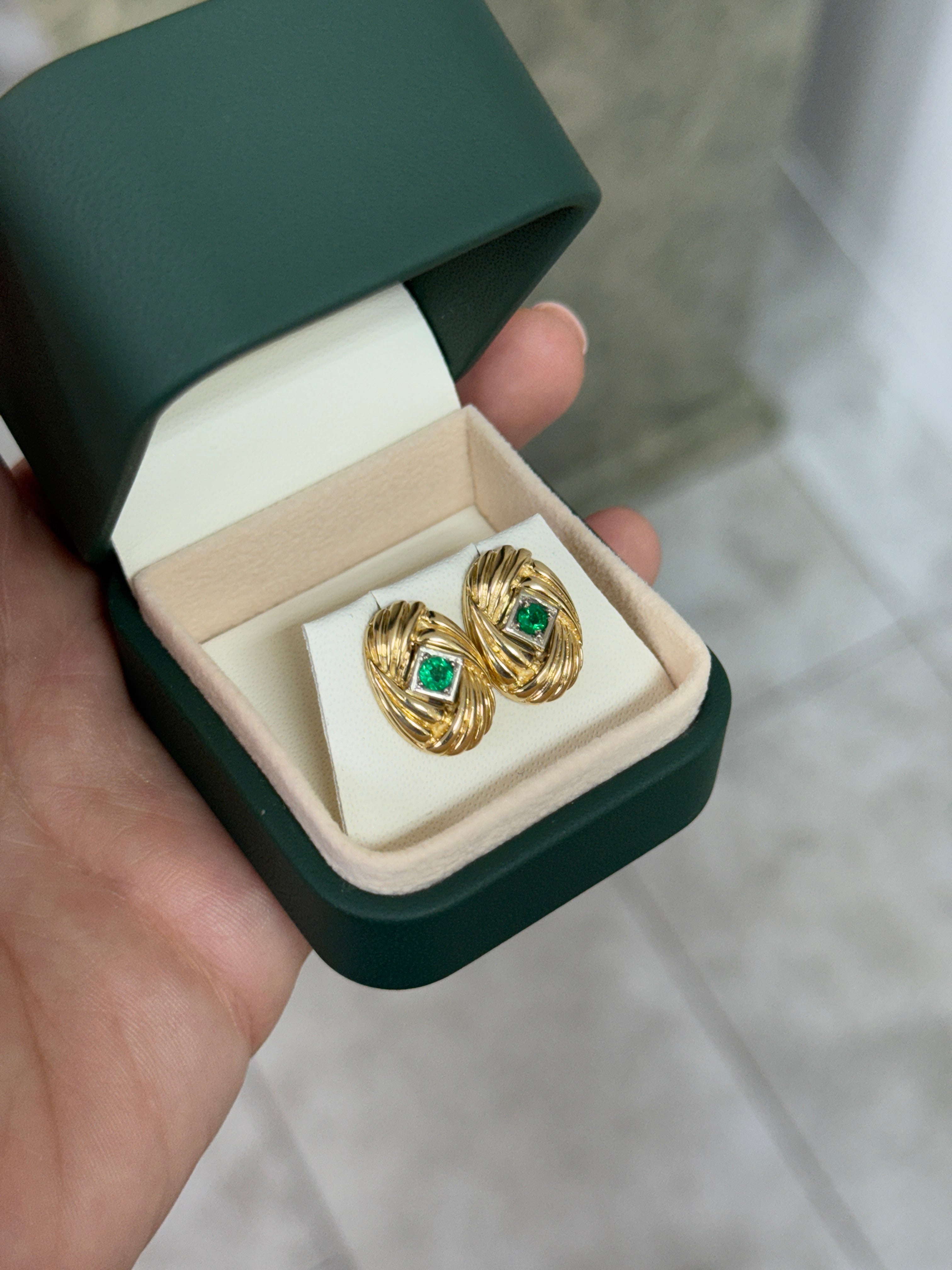 14K gold vintage Zambian emerald statement earrings with scroll and vortex design, featuring 0.70 carats total weight.
