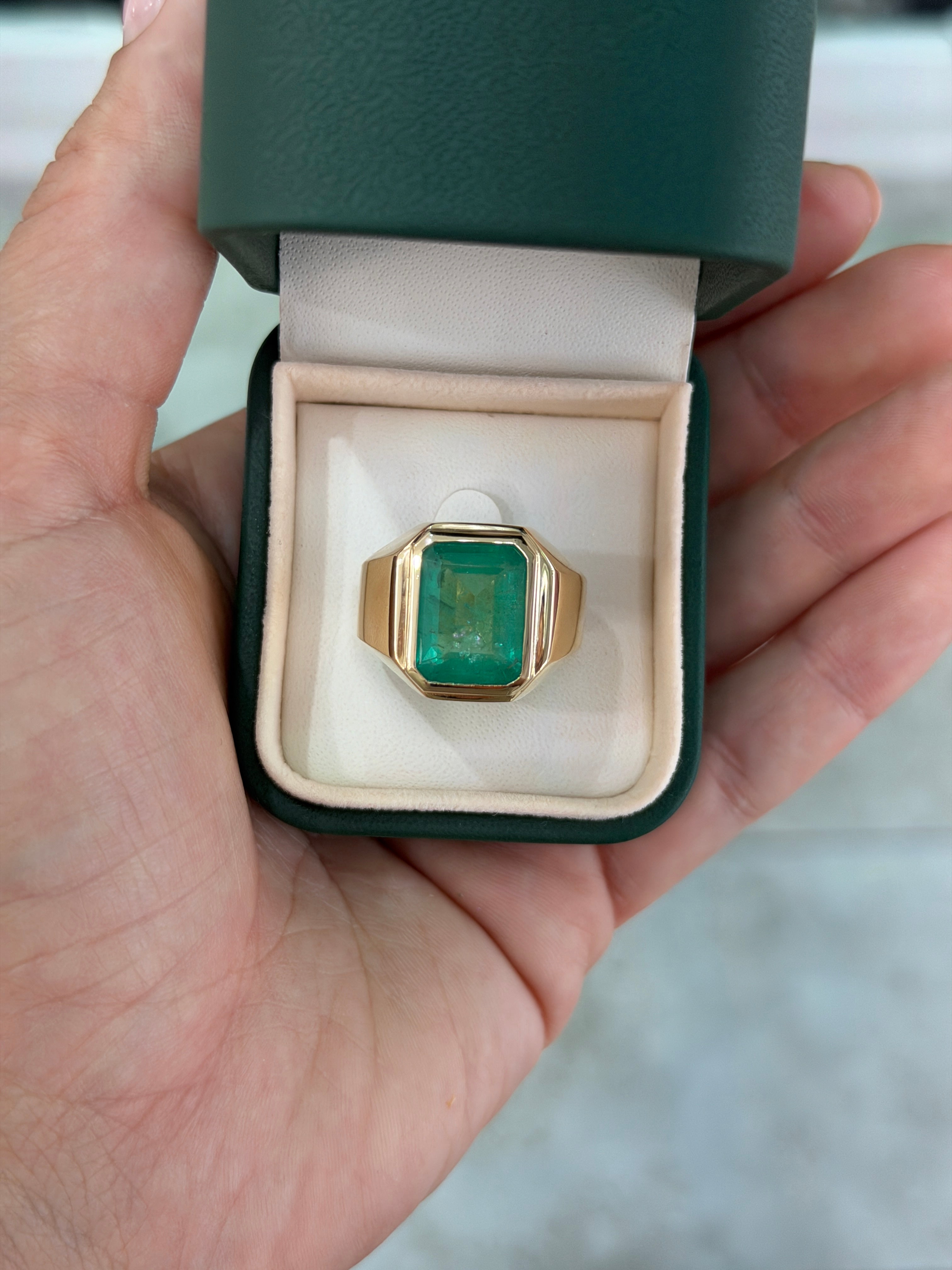 9.64 carat bezel set emerald men's signet ring in 14K yellow gold displayed in green box