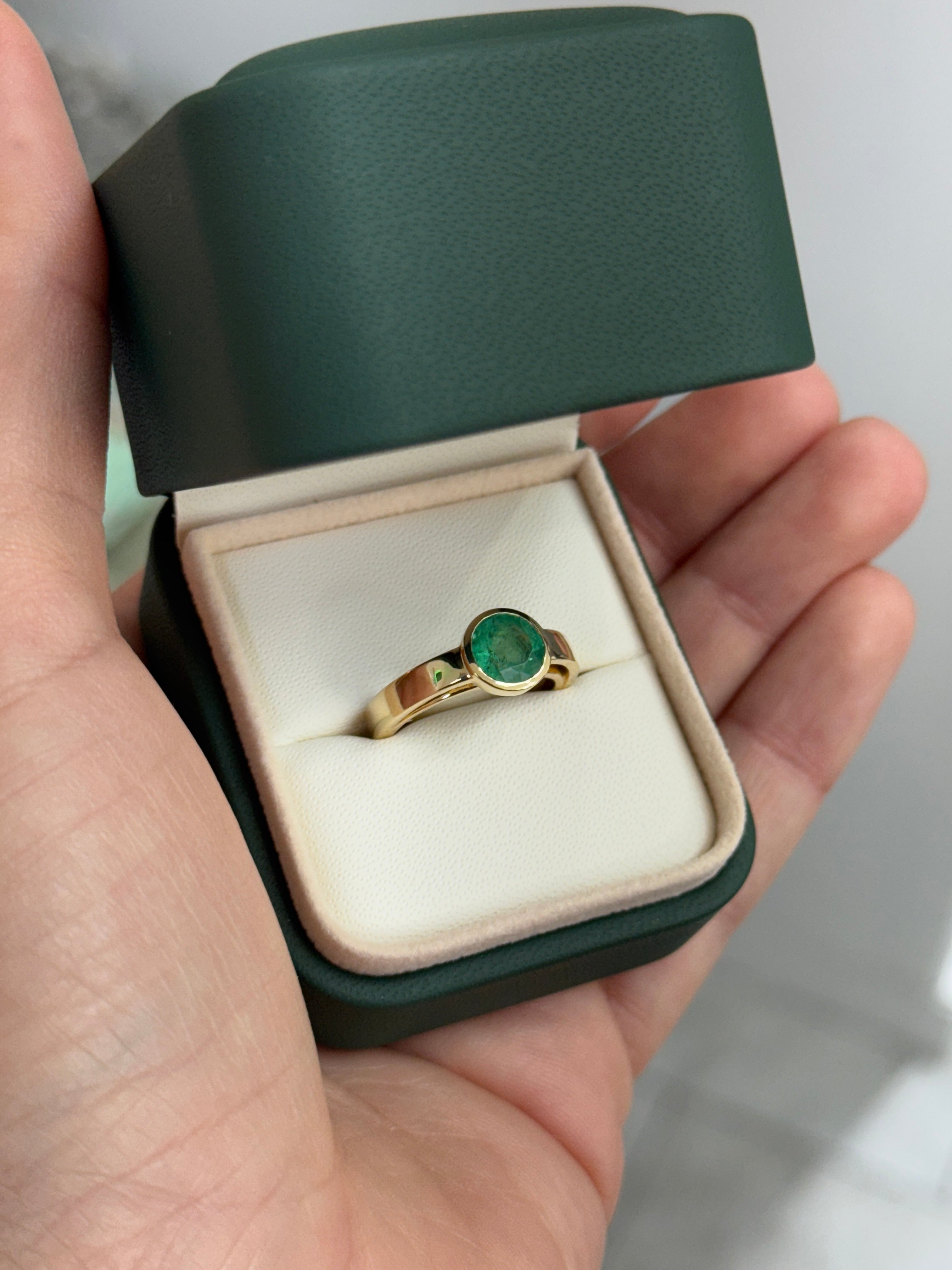 14K gold bezel set round emerald solitaire ring featuring a 1.73 carat emerald by JR Colombian Emeralds.
