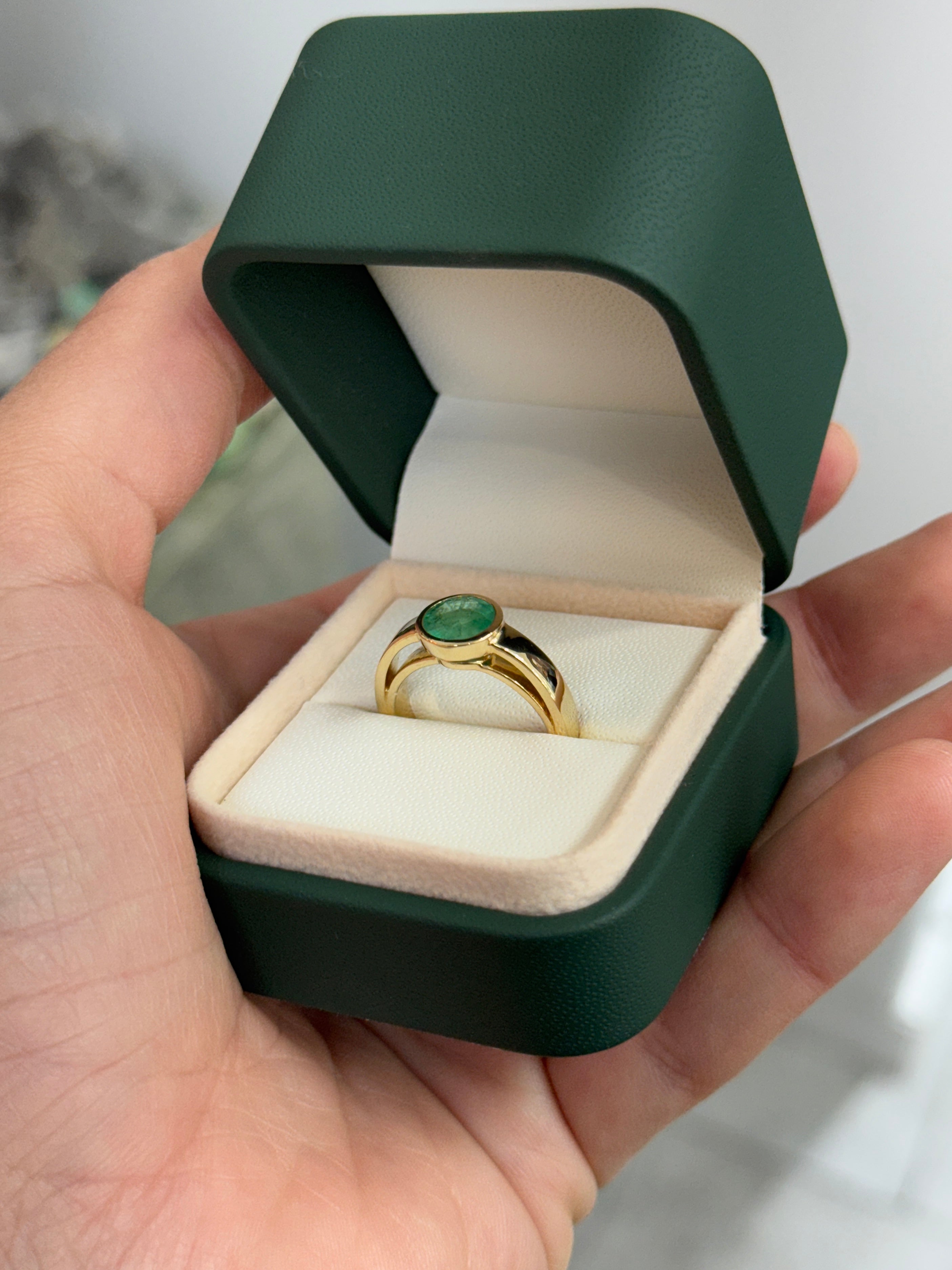 14K gold bezel set round emerald solitaire ring featuring a 1.73 carat Colombian emerald gemstone.