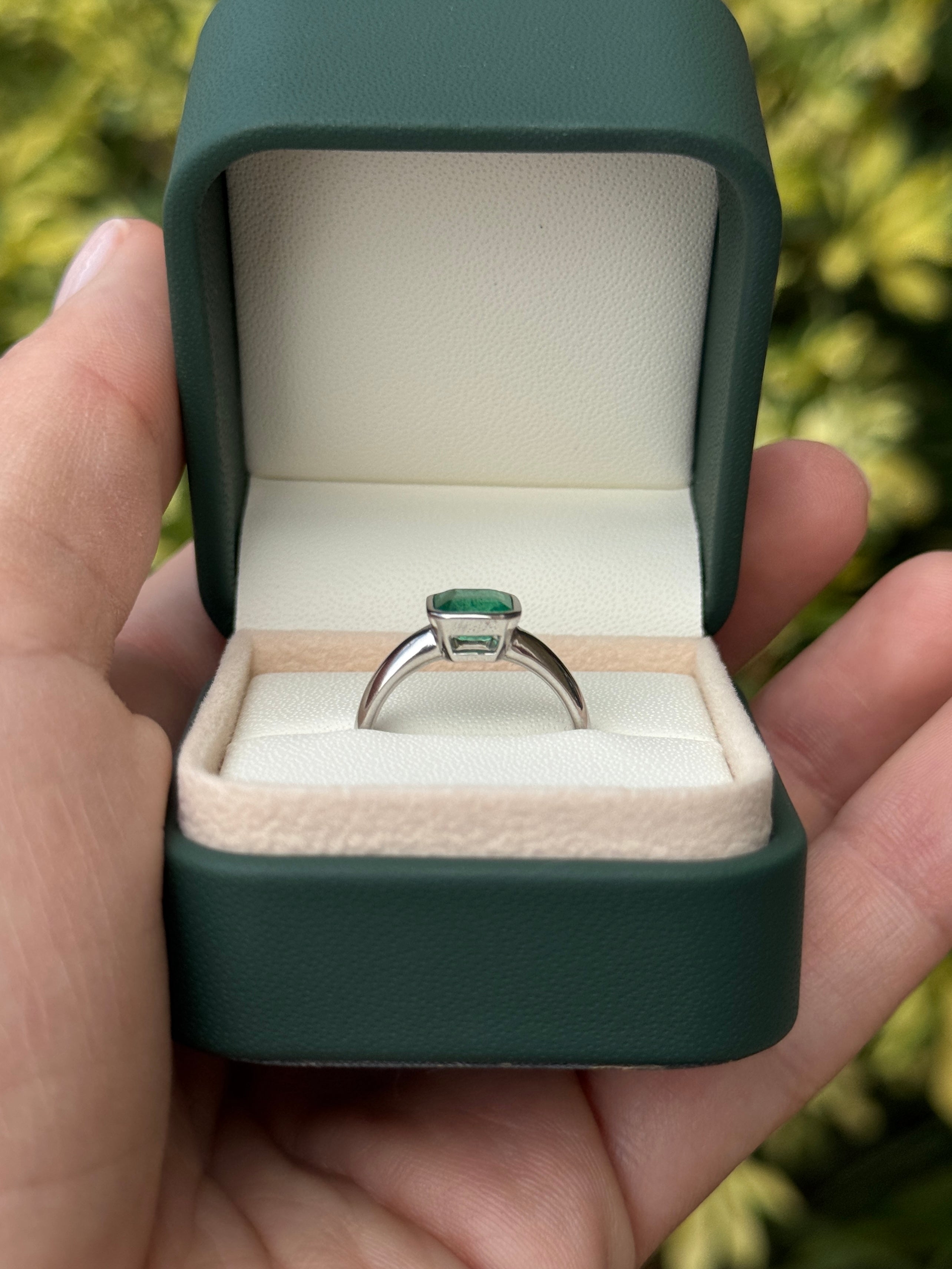 1.32 carat bezel set Asscher cut emerald white gold solitaire ring by JR Colombian Emeralds, showcasing a sparkling green gemstone.
