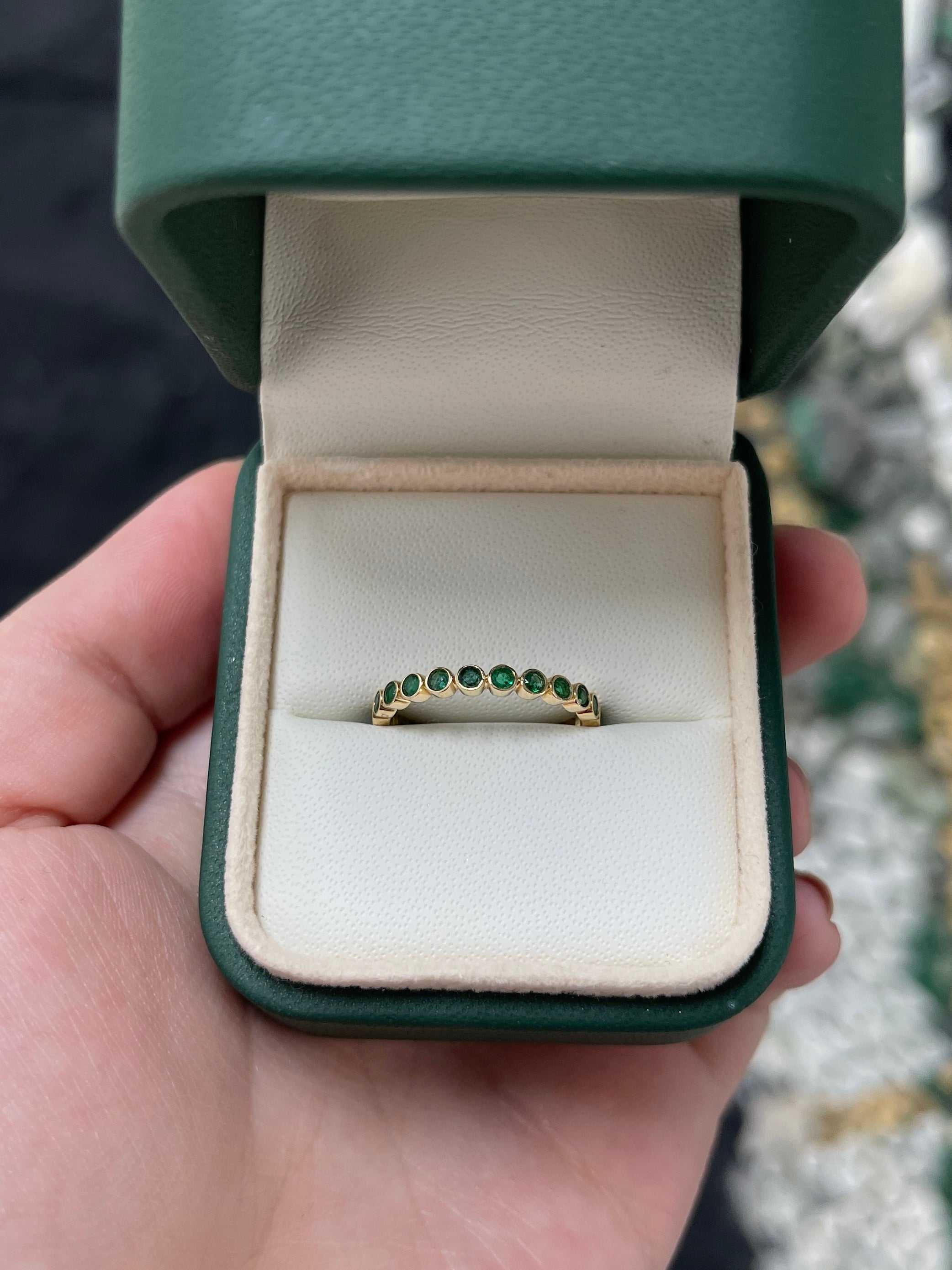 14K gold bezel set round emerald eternity band size 7 in green jewelry box.