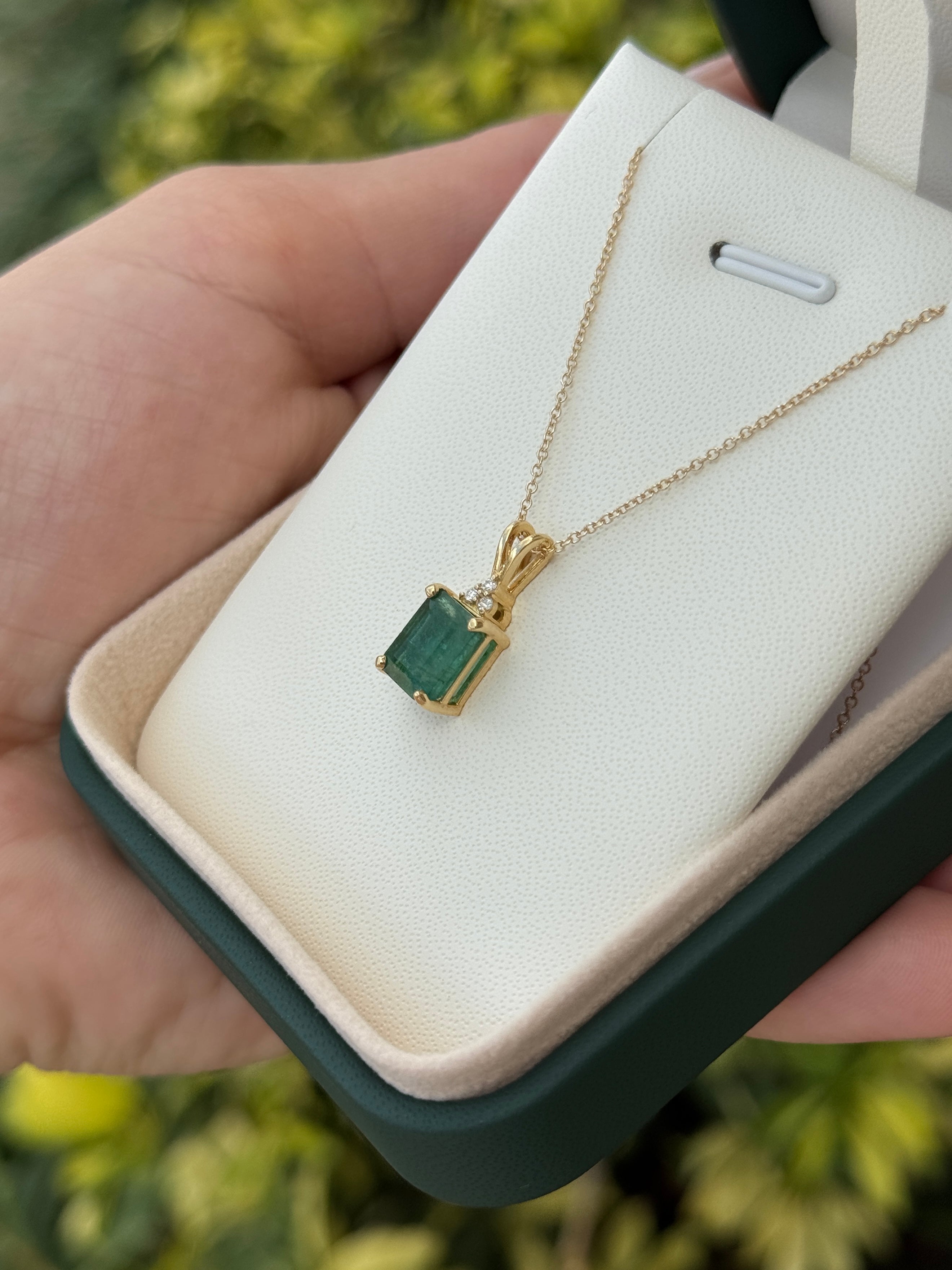 Emerald cut emerald pendant with trefoil diamond accents in 14K gold from JR Colombian Emeralds, showcasing the elegant jewelry piece.