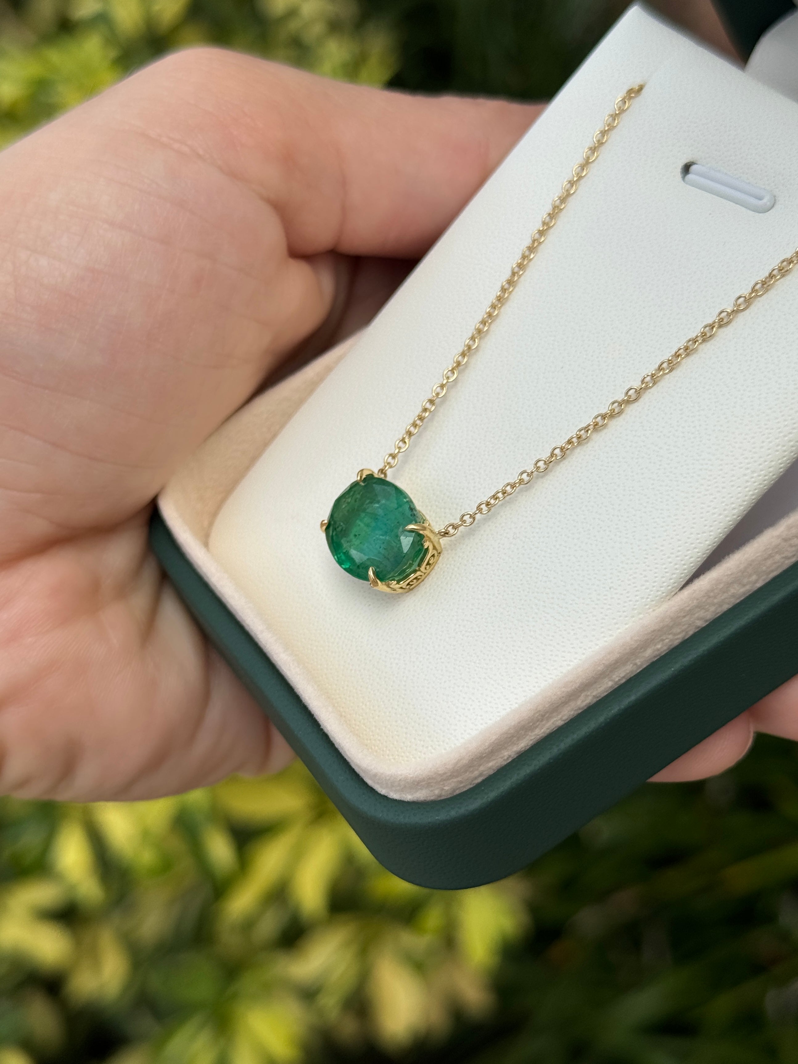 6.80ct 18K gold natural emerald oval fleur de lis necklace by JR Colombian Emeralds, showcasing a detailed pendant design.
