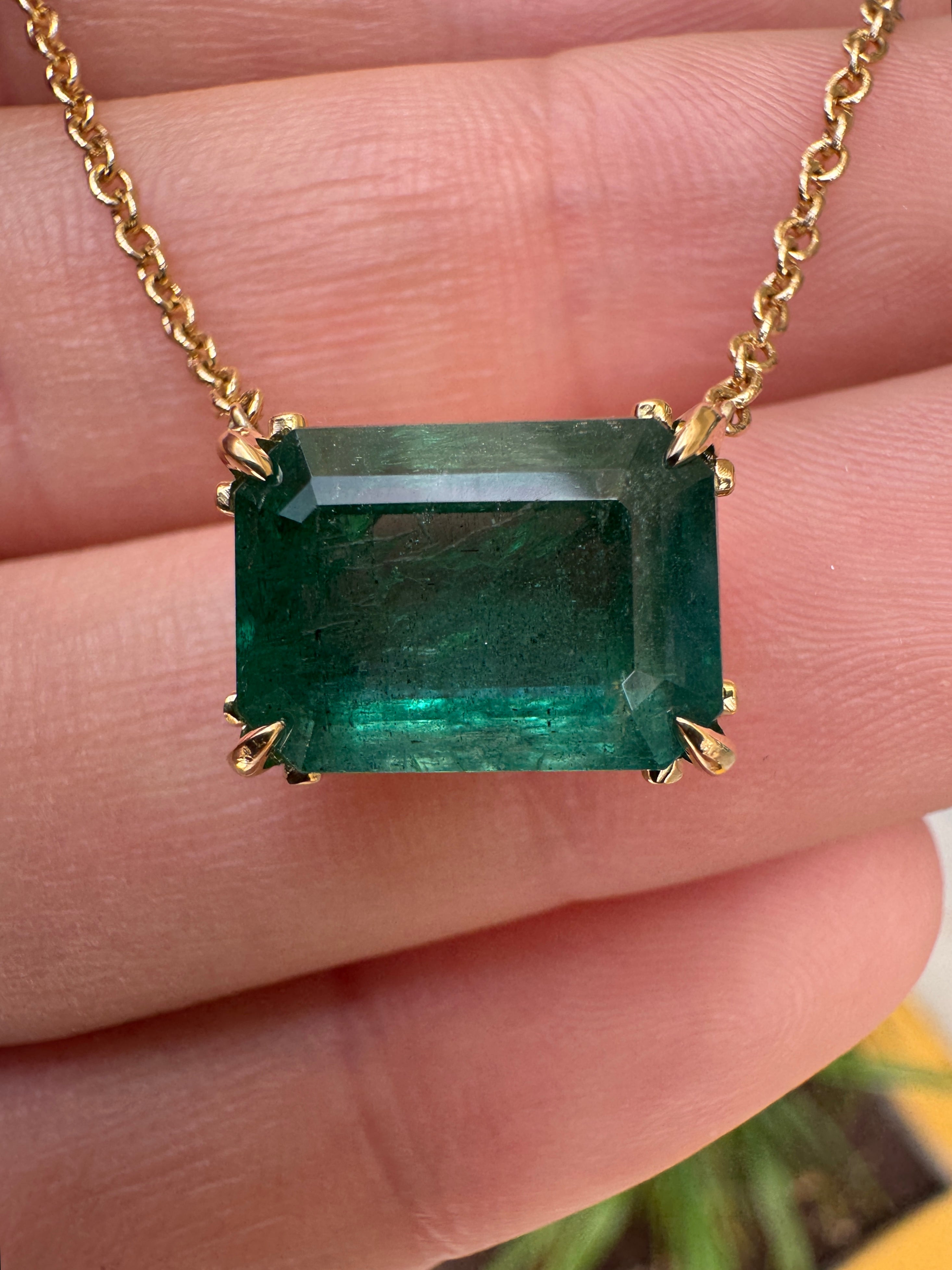 18K gold emerald solitaire necklace with east-west station, floral Fleur de Lis design, featuring a 5.70ct natural Colombian emerald.