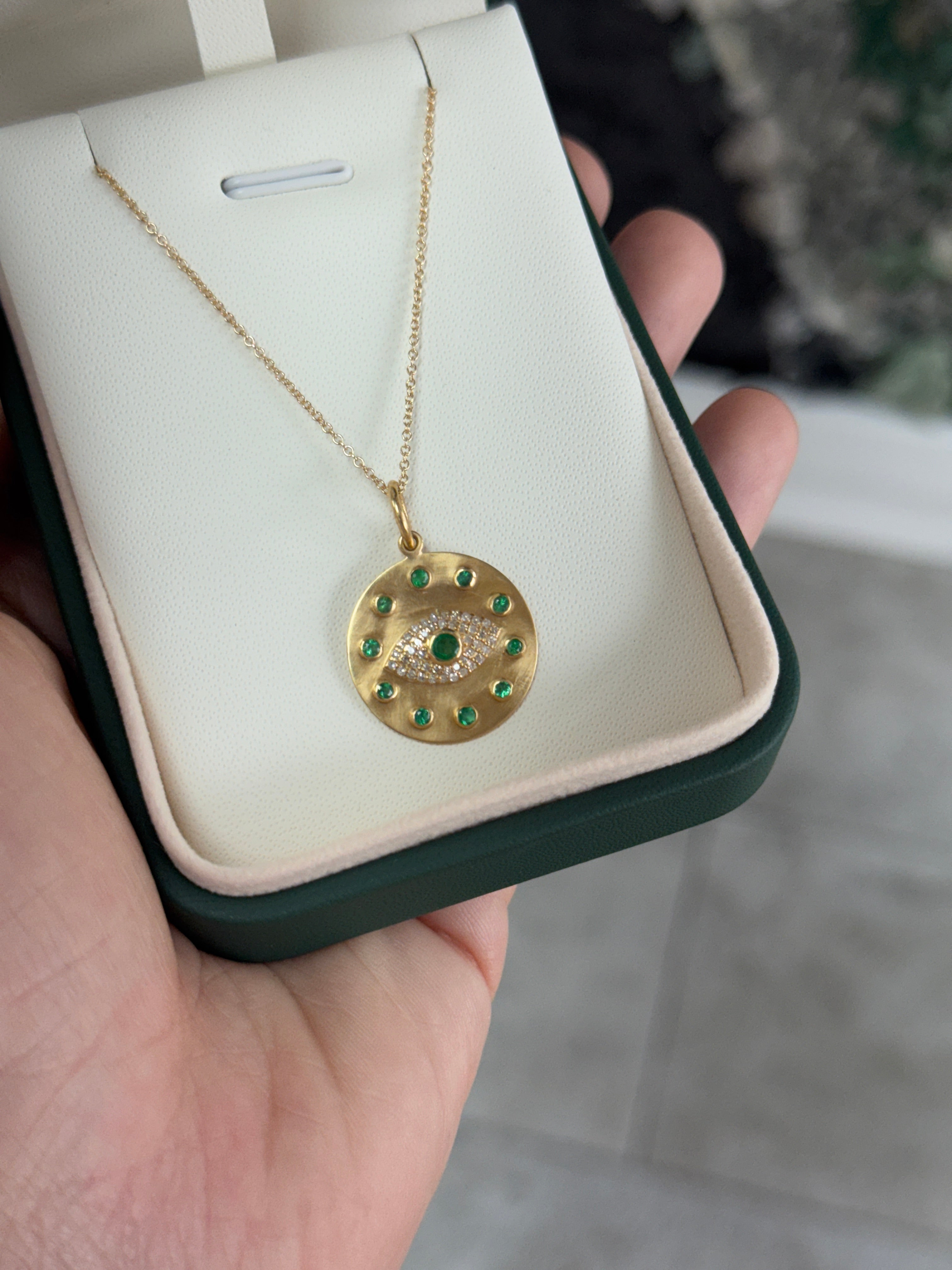 14K gold emerald and diamond evil eye charm pendant with protective design, featuring natural green emeralds and sparkling diamonds.