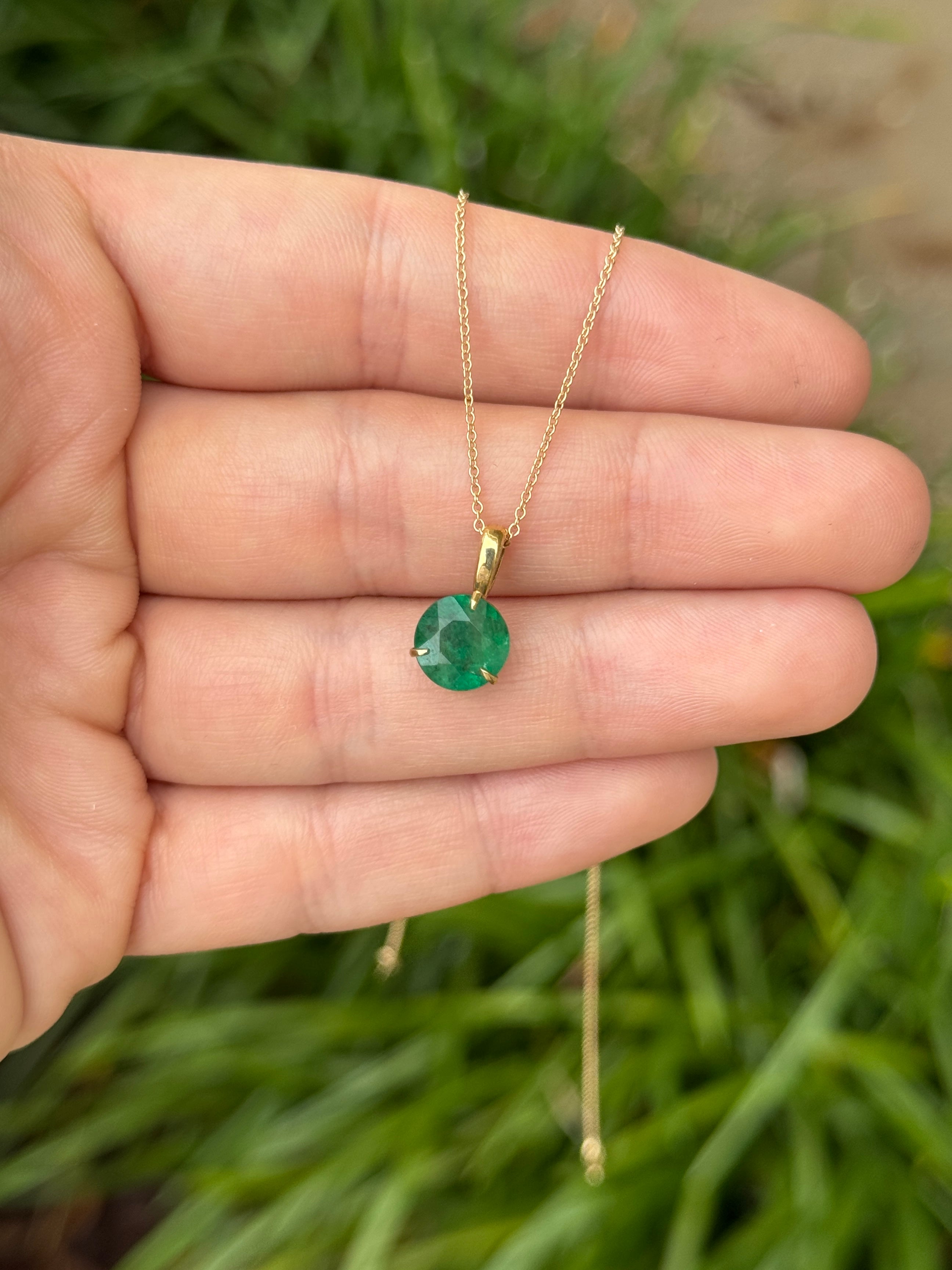 14K gold emerald solitaire necklace with a 1.66 carat round emerald in a three-prong setting, featuring the JR Colombian Emeralds brand.