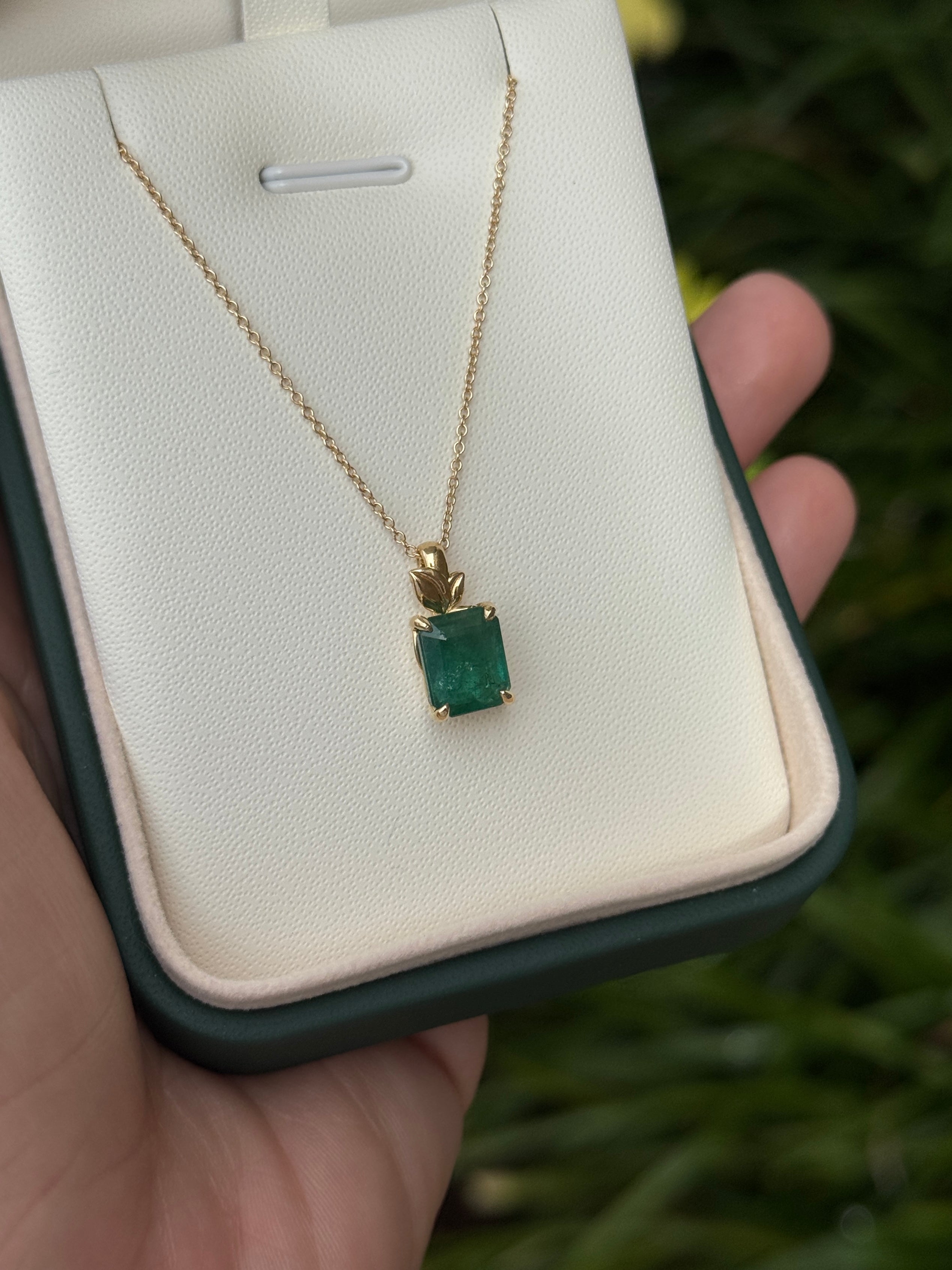 Emerald cut emerald pendant with leaf design on 14K gold chain from JR Colombian Emeralds, featuring a 2.52 carat natural green emerald.