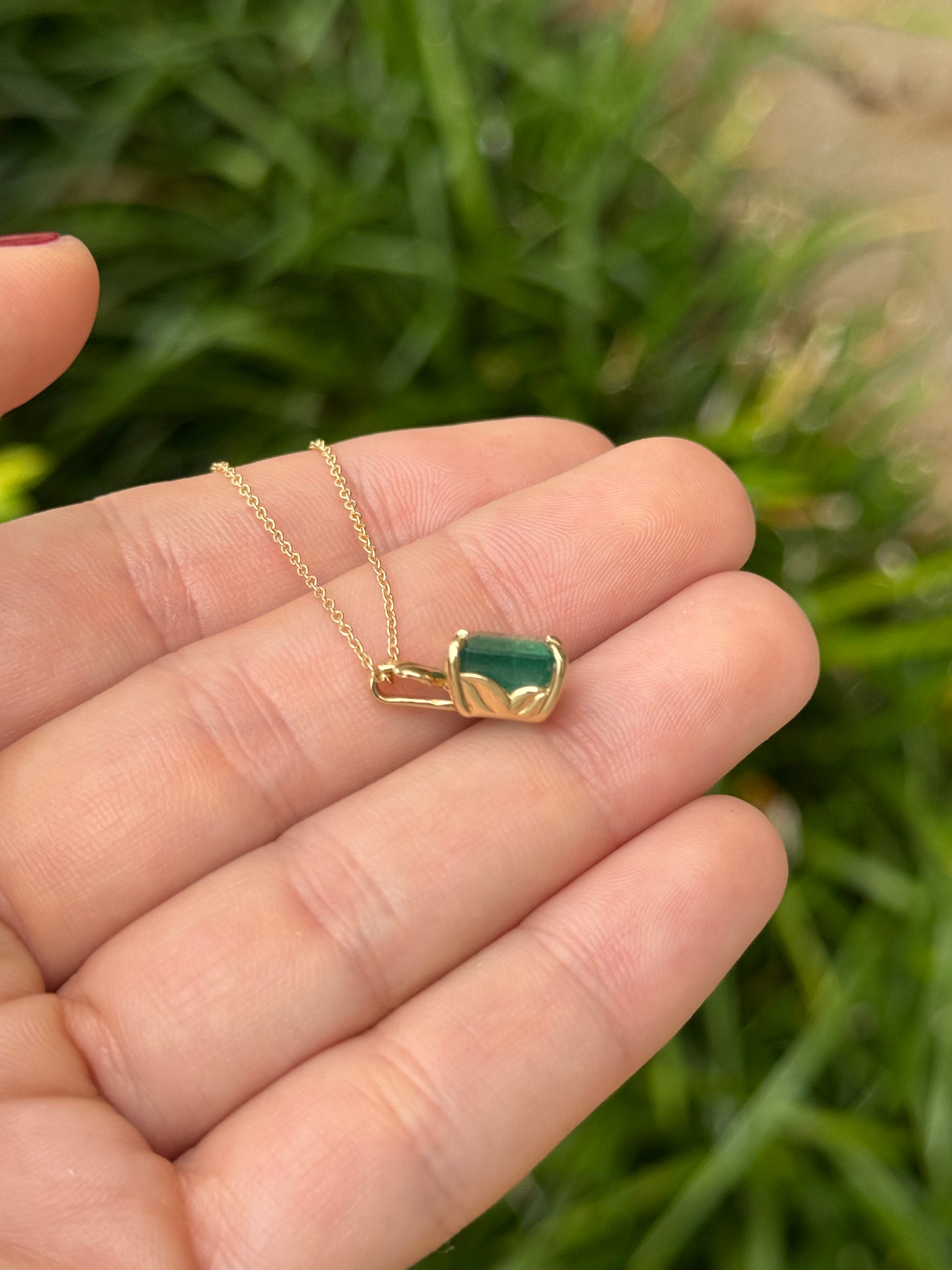Emerald cut emerald pendant with leaf design on 14K gold chain, nature-inspired jewelry from JR Colombian Emeralds.