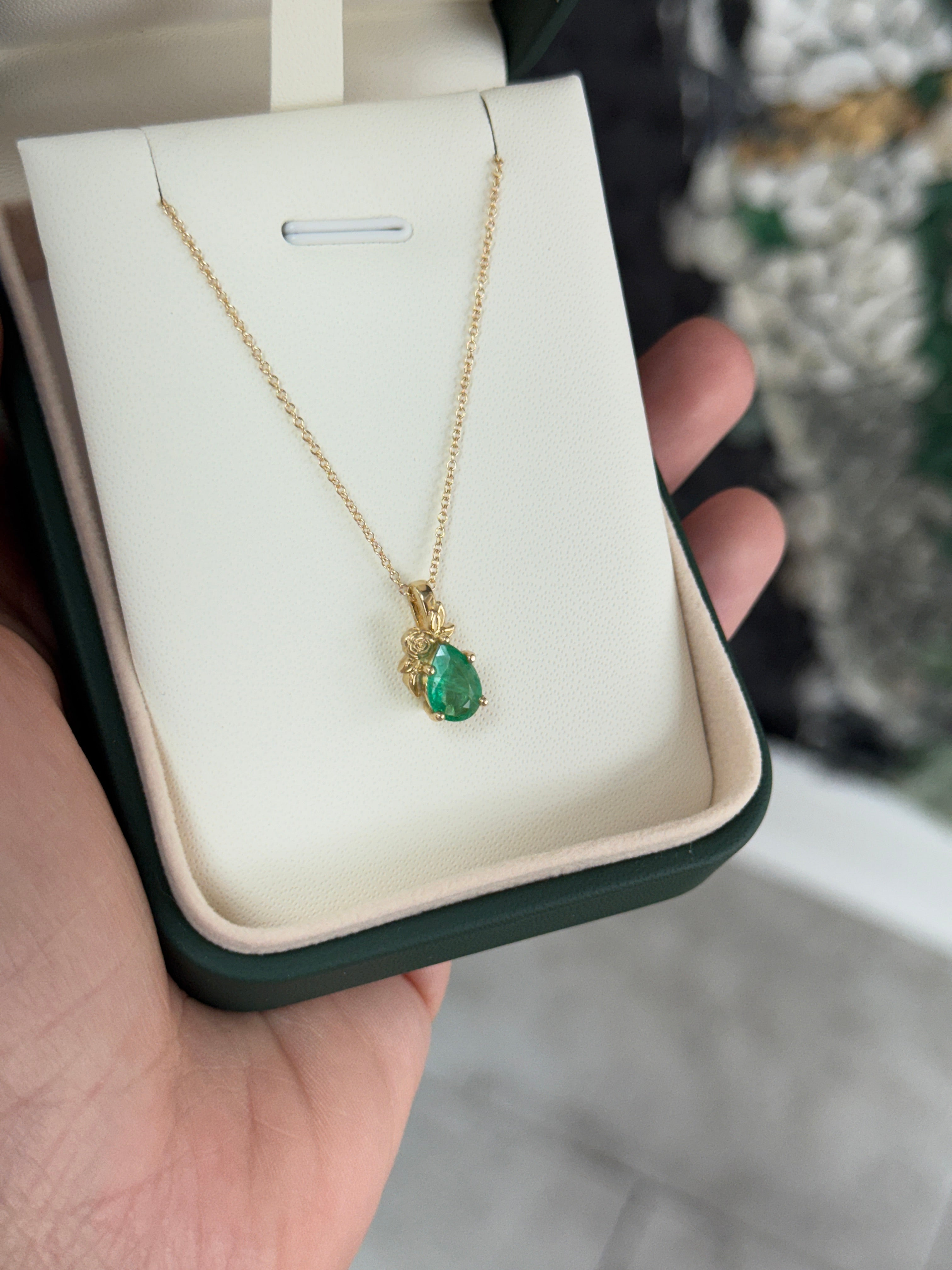 14K gold pendant necklace with a 1.0ct natural medium green pear cut emerald in a floral solitaire setting by JR Colombian Emeralds.
