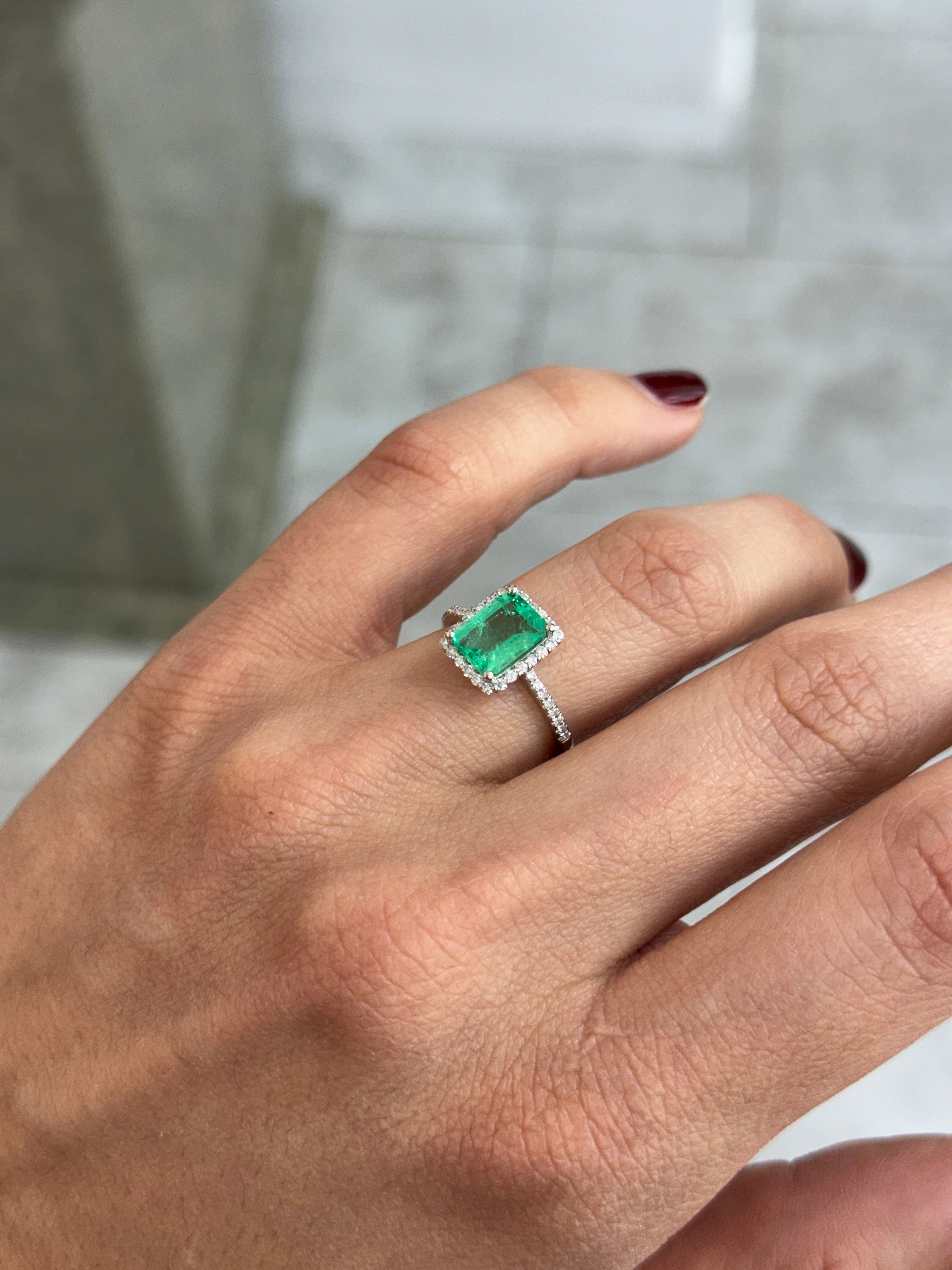 Elegant engagement ring featuring a 1.70tcw Colombian emerald surrounded by diamonds in 14K white gold, by JR Colombian Emeralds.
