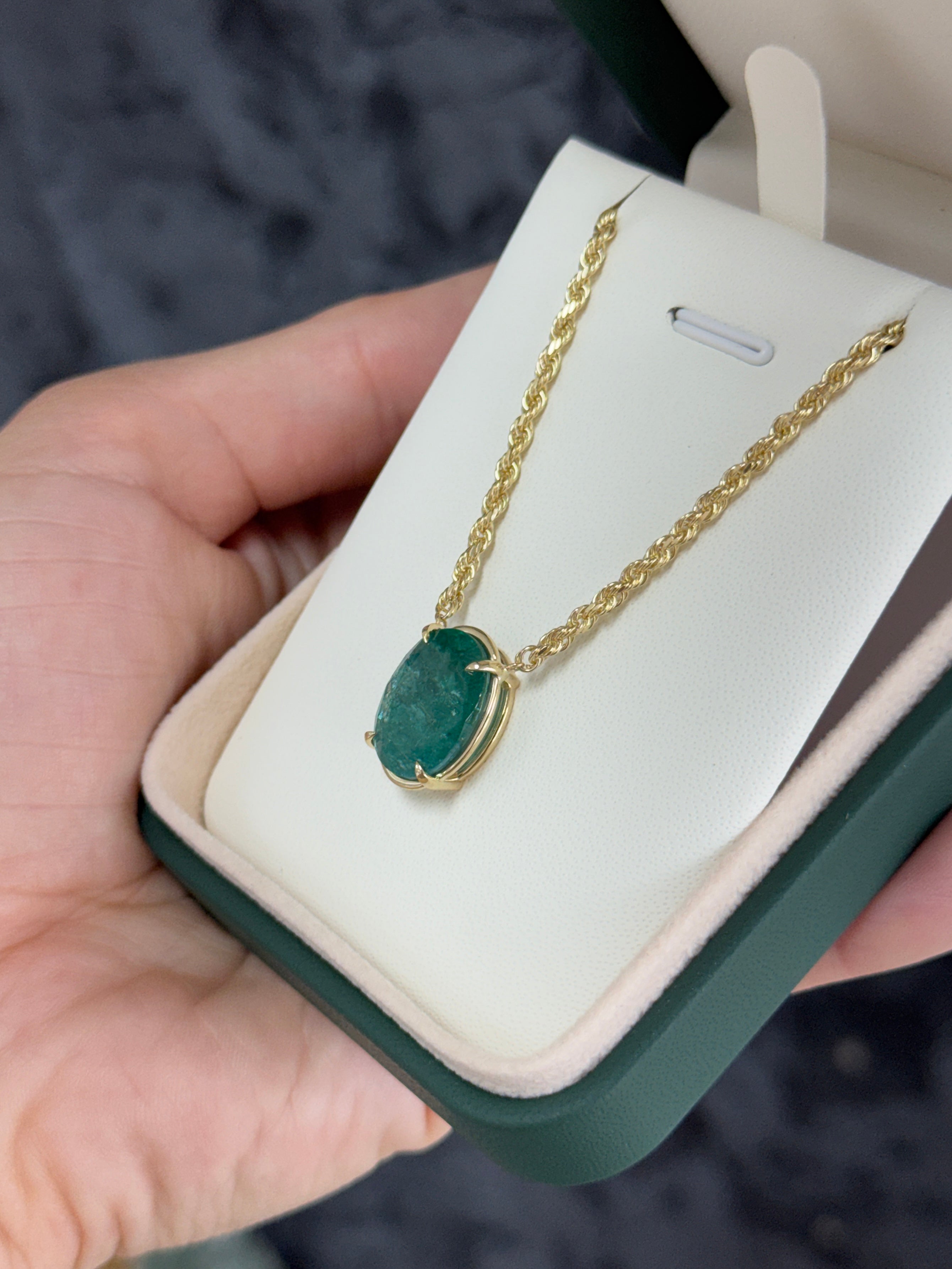 9 carat oval emerald solitaire necklace in solid yellow 14K gold with a delicate chain, featuring a prominent emerald gemstone.