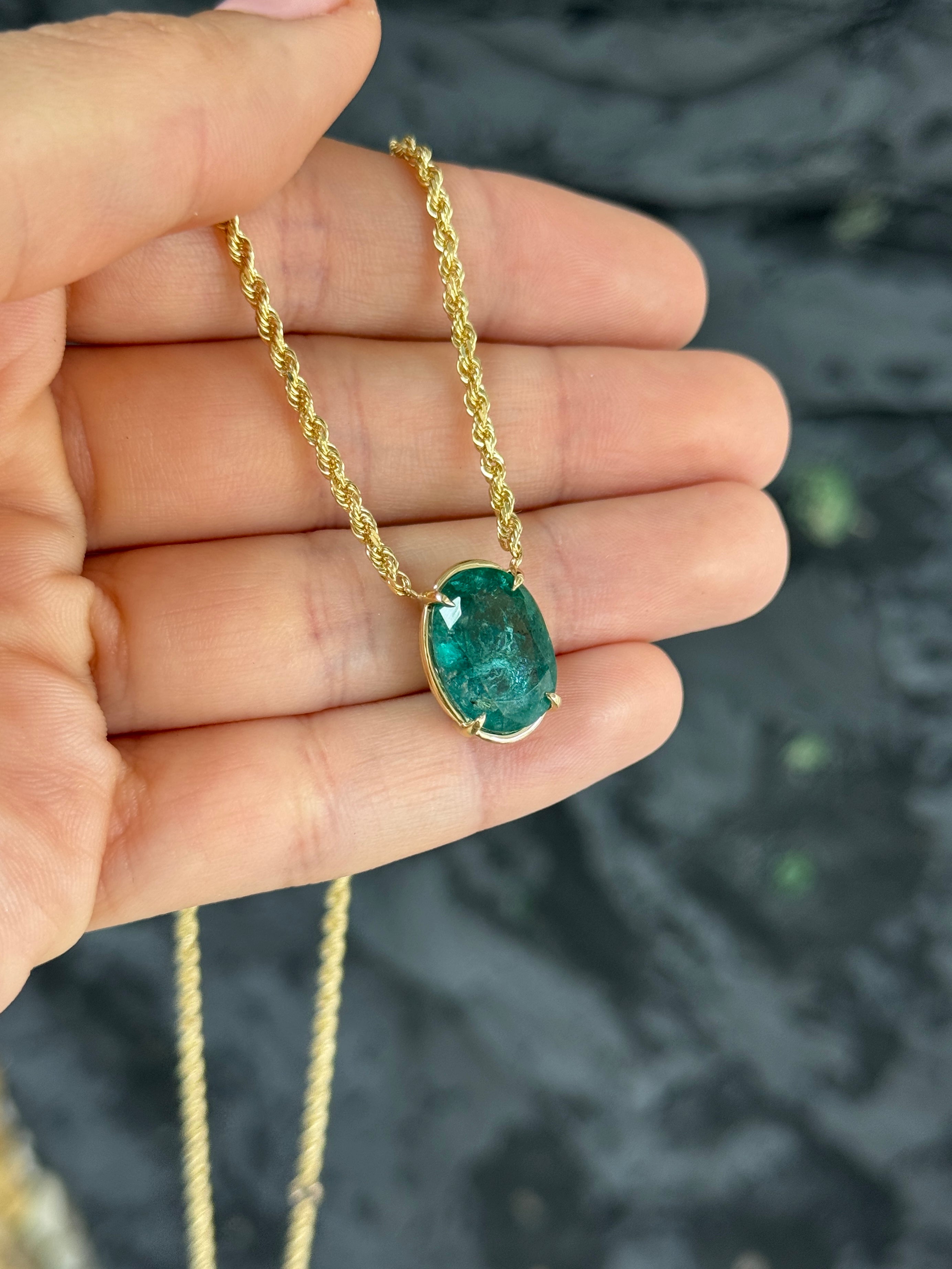 Oval emerald solitaire necklace in 14K yellow gold with a 9-carat gemstone, featuring a stationary pendant design.