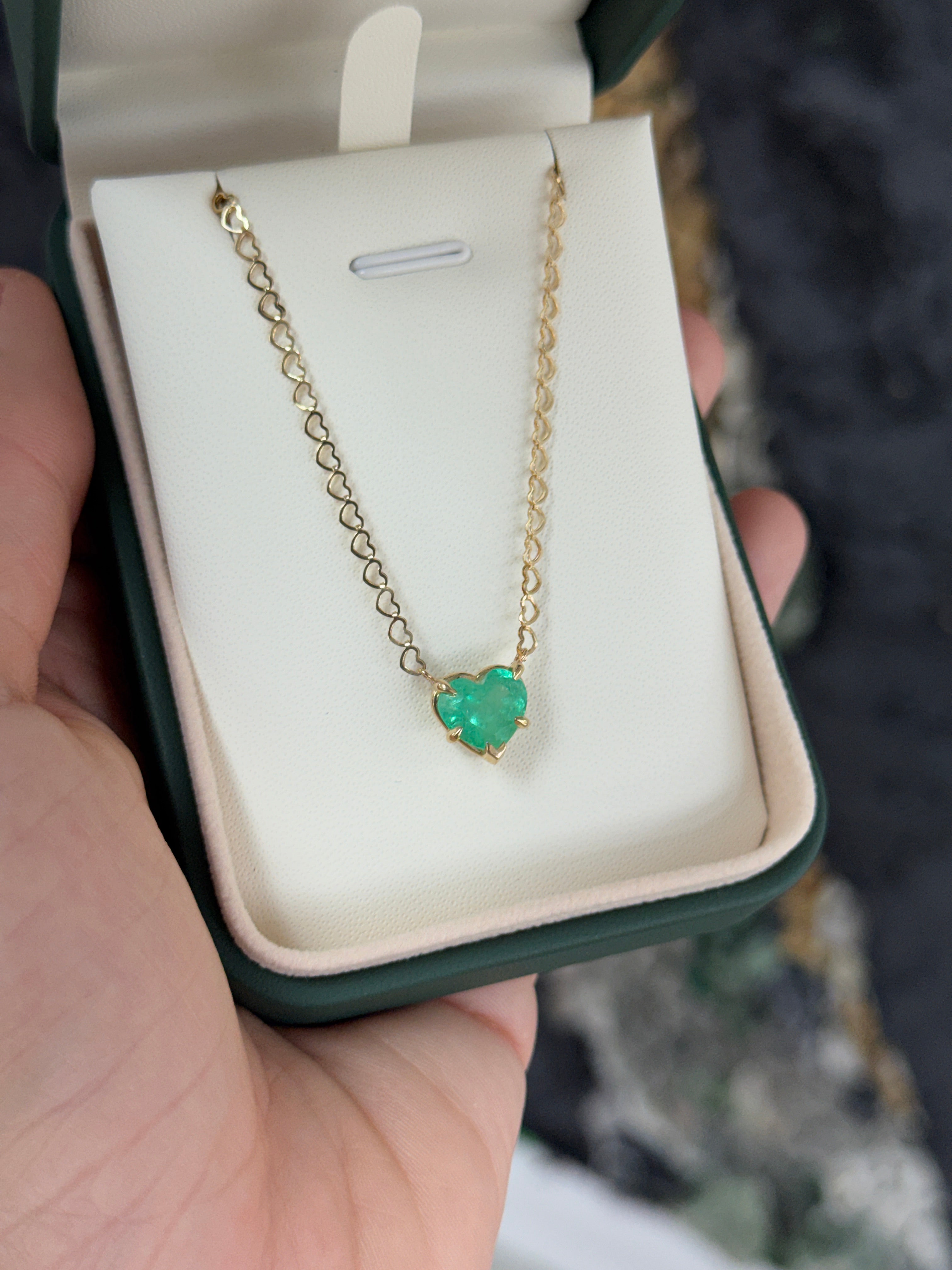 Natural Colombian emerald heart pendant on 14K necklace with solitaire setting, showcasing vibrant green gemstone and elegant design.