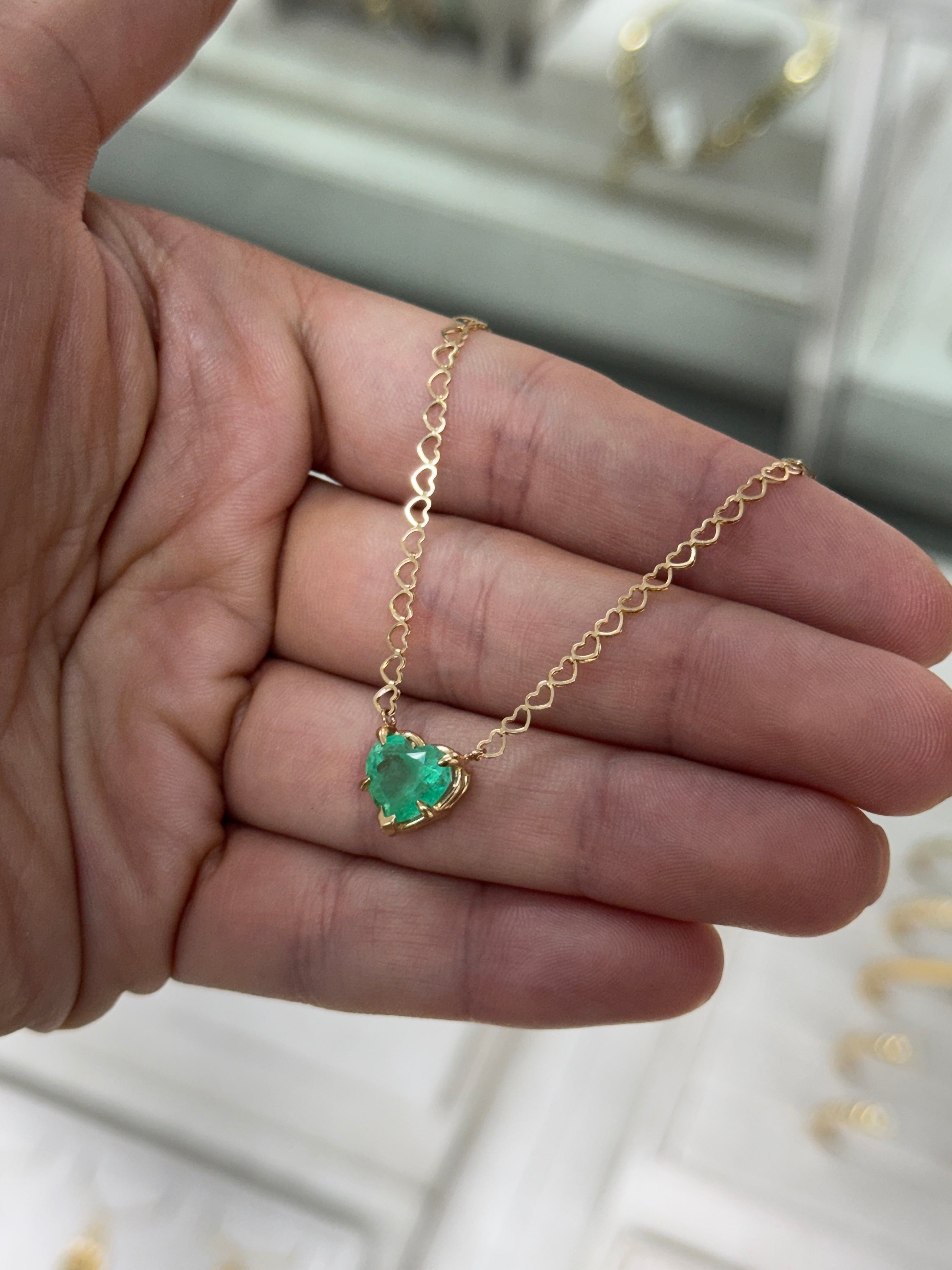 Natural Colombian emerald heart pendant on a 14K necklace, featuring a 2.70-carat emerald in a solitaire station design.