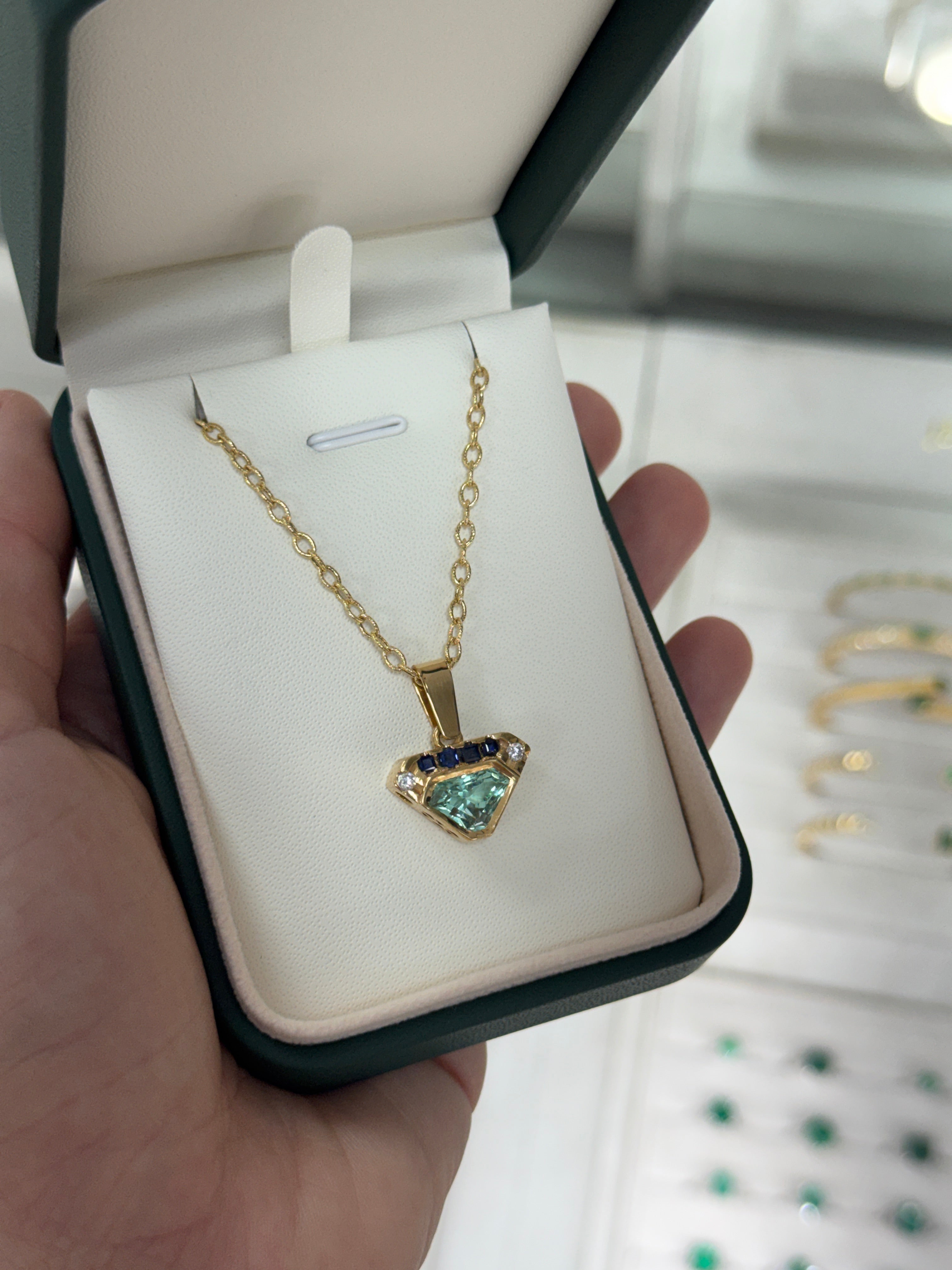 VVS clarity Colombian emerald shield cut pendant with blue sapphire and diamonds from JR Colombian Emeralds.