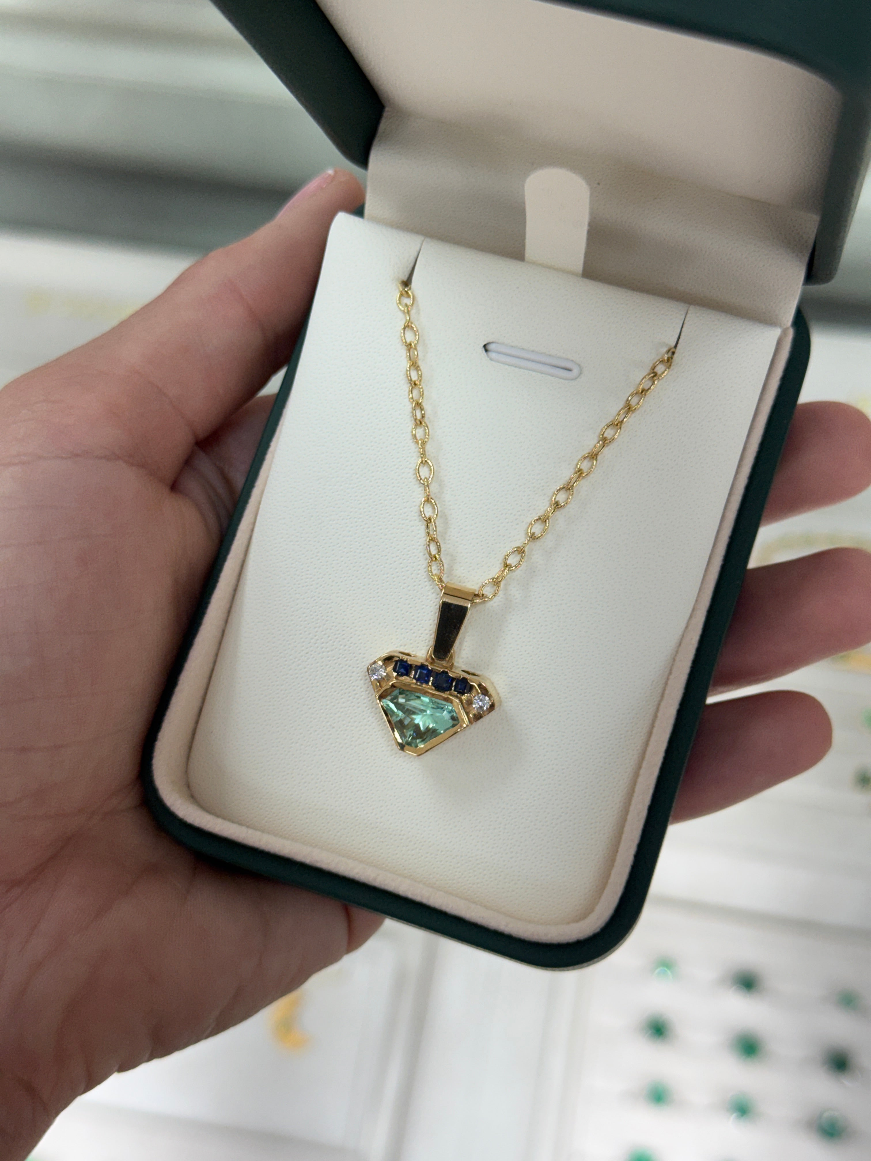 VVS clarity Colombian emerald shield cut pendant with blue sapphire and diamonds, featuring 2.80tcw jewelry design by JR Colombian Emeralds.