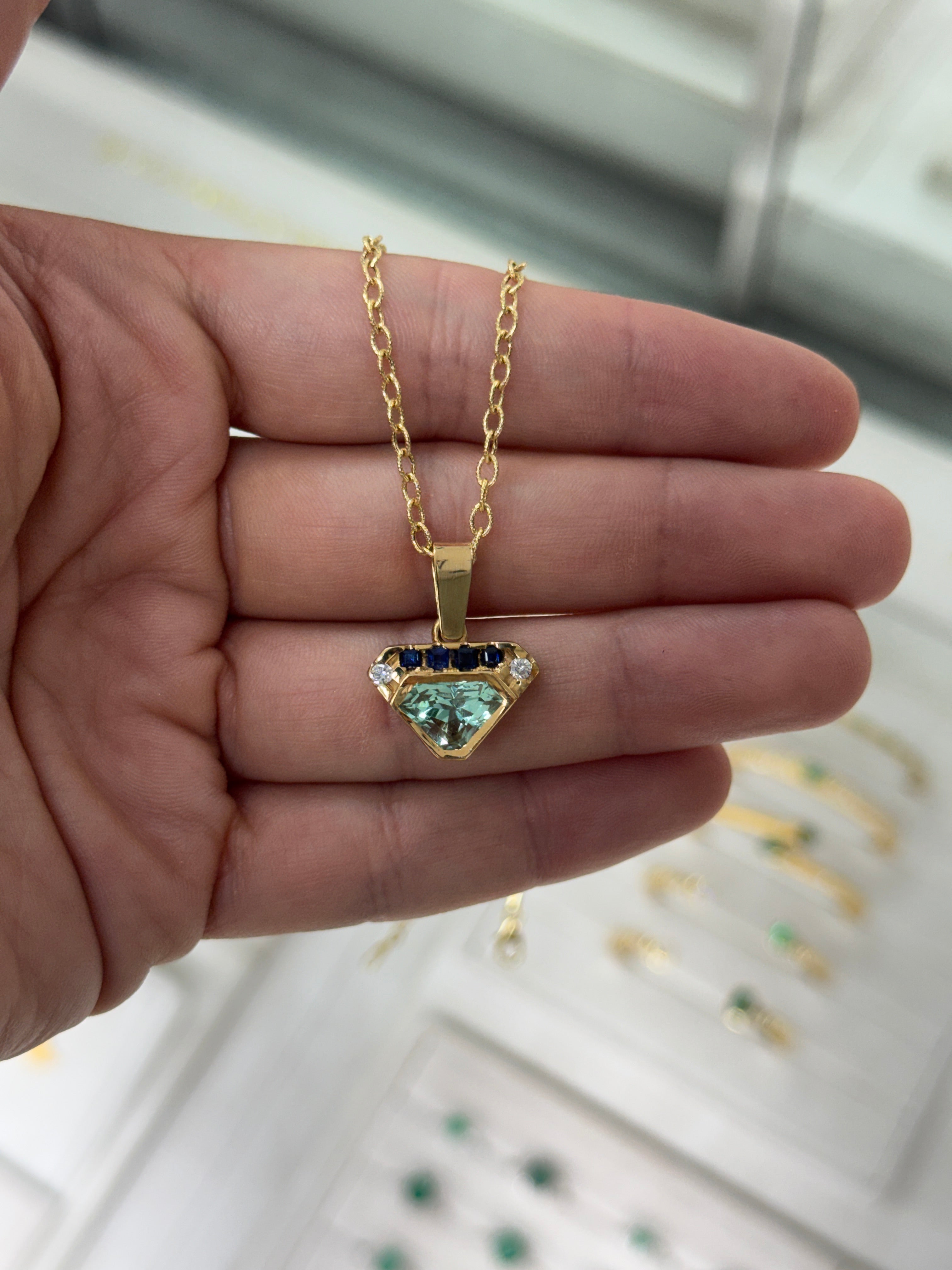 VVS clarity Colombian emerald shield cut pendant with blue sapphire and diamonds from JR Colombian Emeralds.