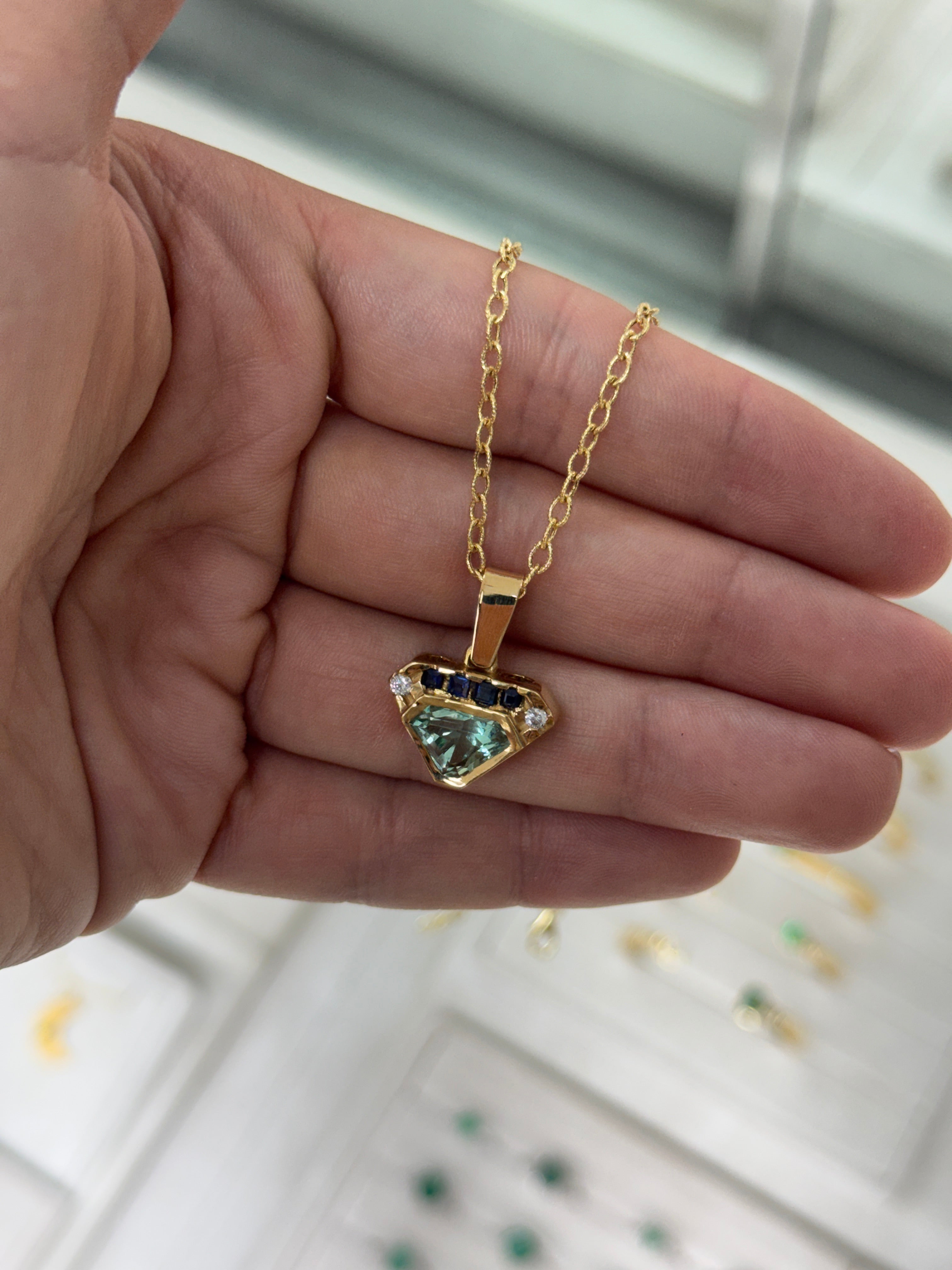 VVS clarity Colombian emerald shield cut pendant with blue sapphire and diamonds, featuring 2.80tcw from JR Colombian Emeralds.