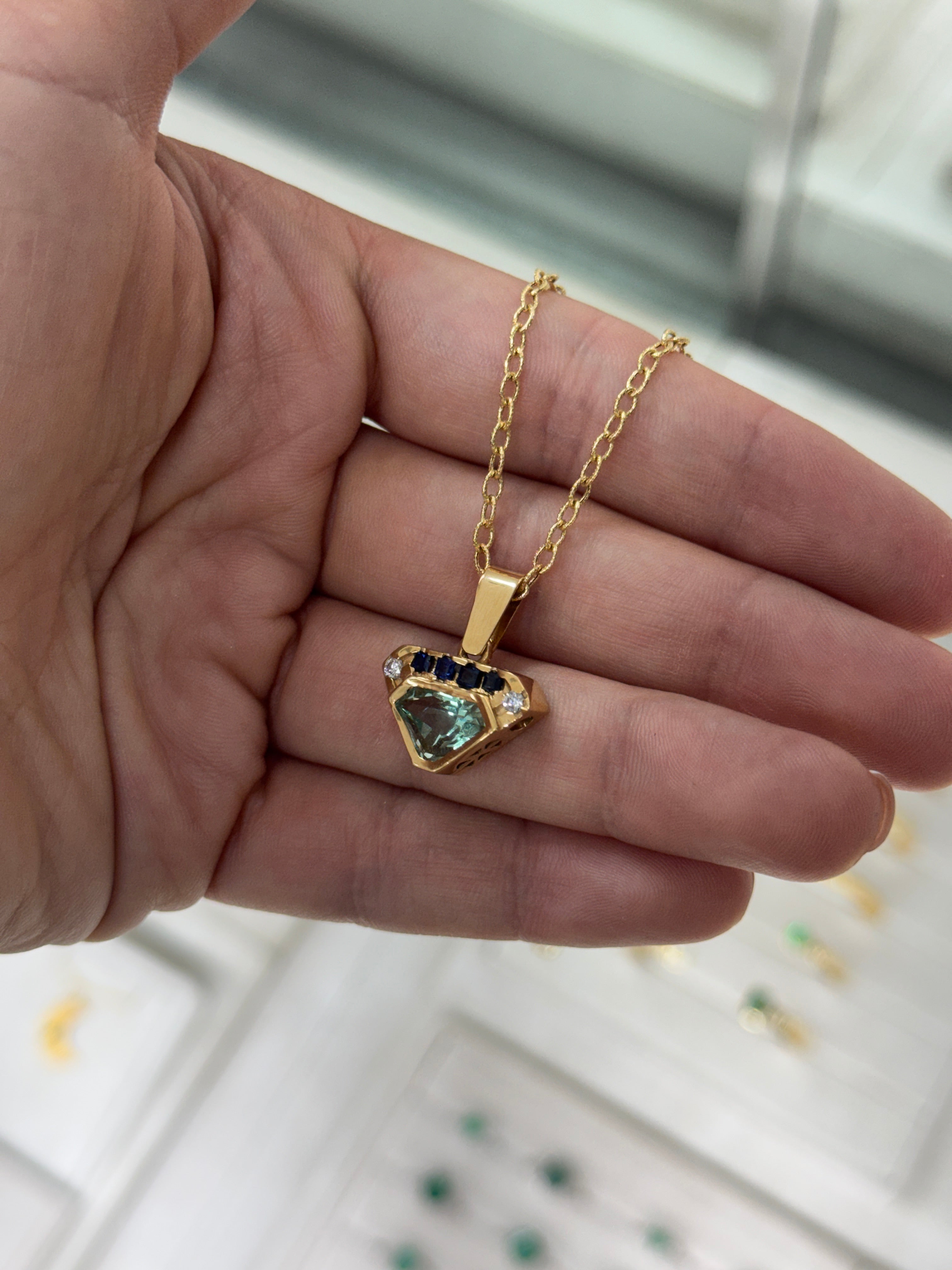 VVS clarity Colombian emerald shield cut pendant with blue sapphire and diamonds by JR Colombian Emeralds