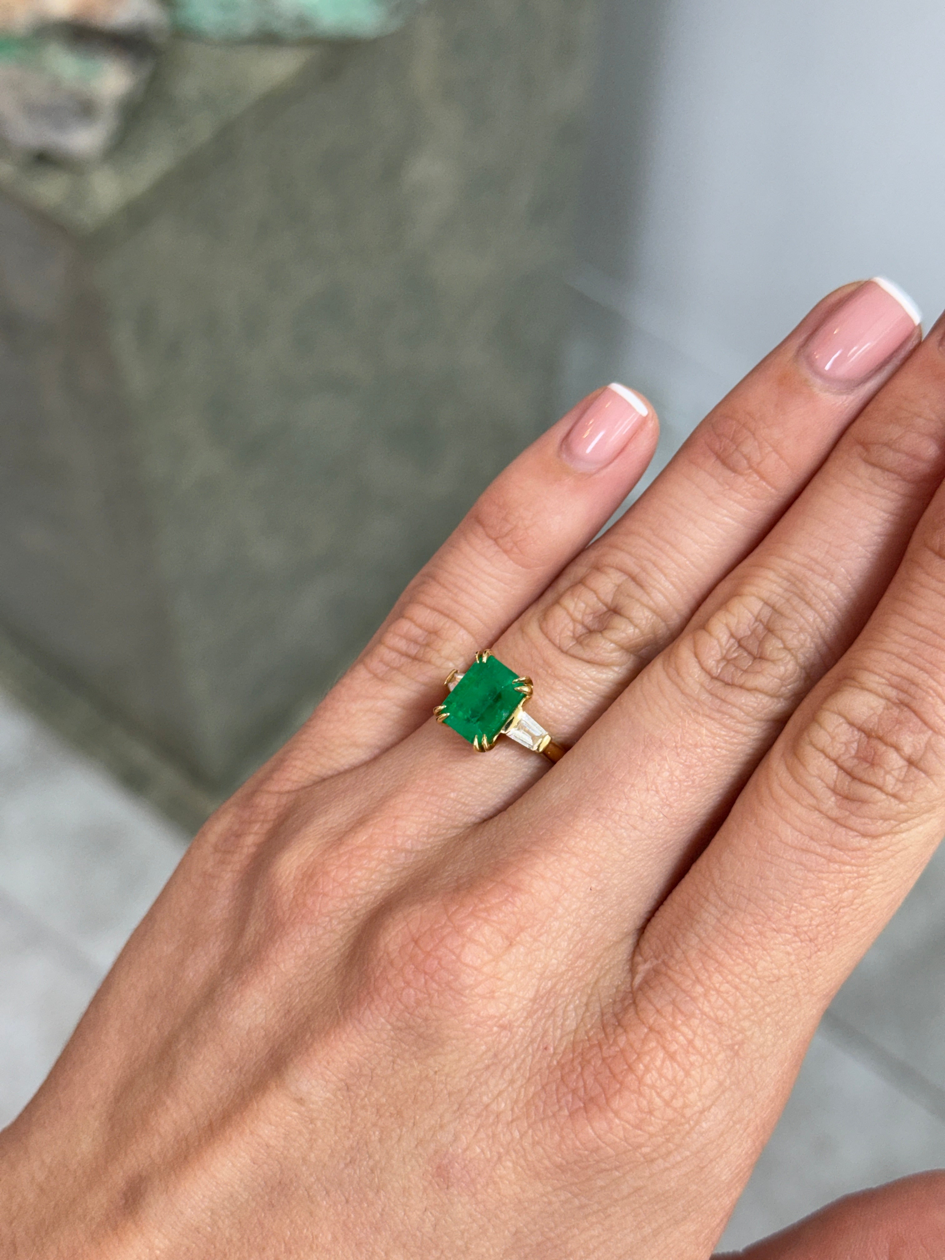18K gold ring featuring 3.36tcw Colombian emeralds and tapered baguette diamonds, showcasing a luxurious jewelry design.