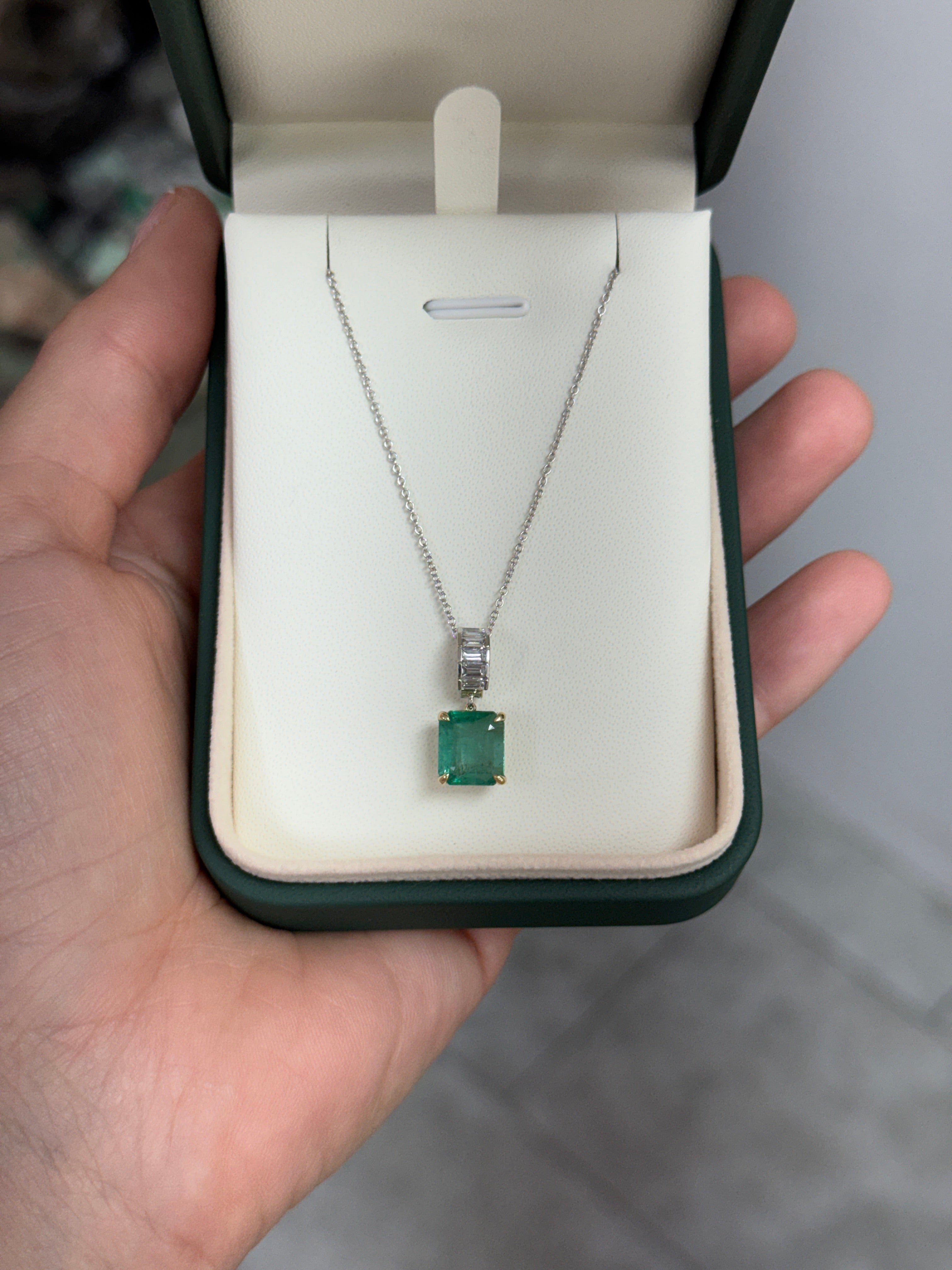 Asscher cut emerald and lab diamond baguette bail pendant in 14K gold, showcasing the jewelry design with green emeralds and sparkling diamonds.