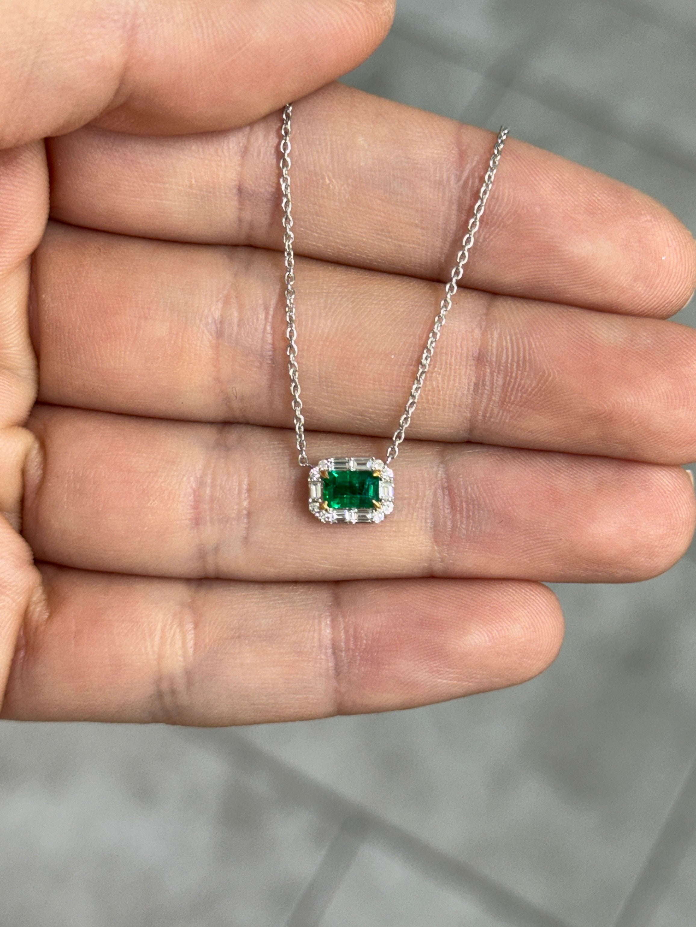AAA+ natural emerald and baguette diamond halo necklace by JR Colombian Emeralds, showcasing an 18K gold east-to-west station design.