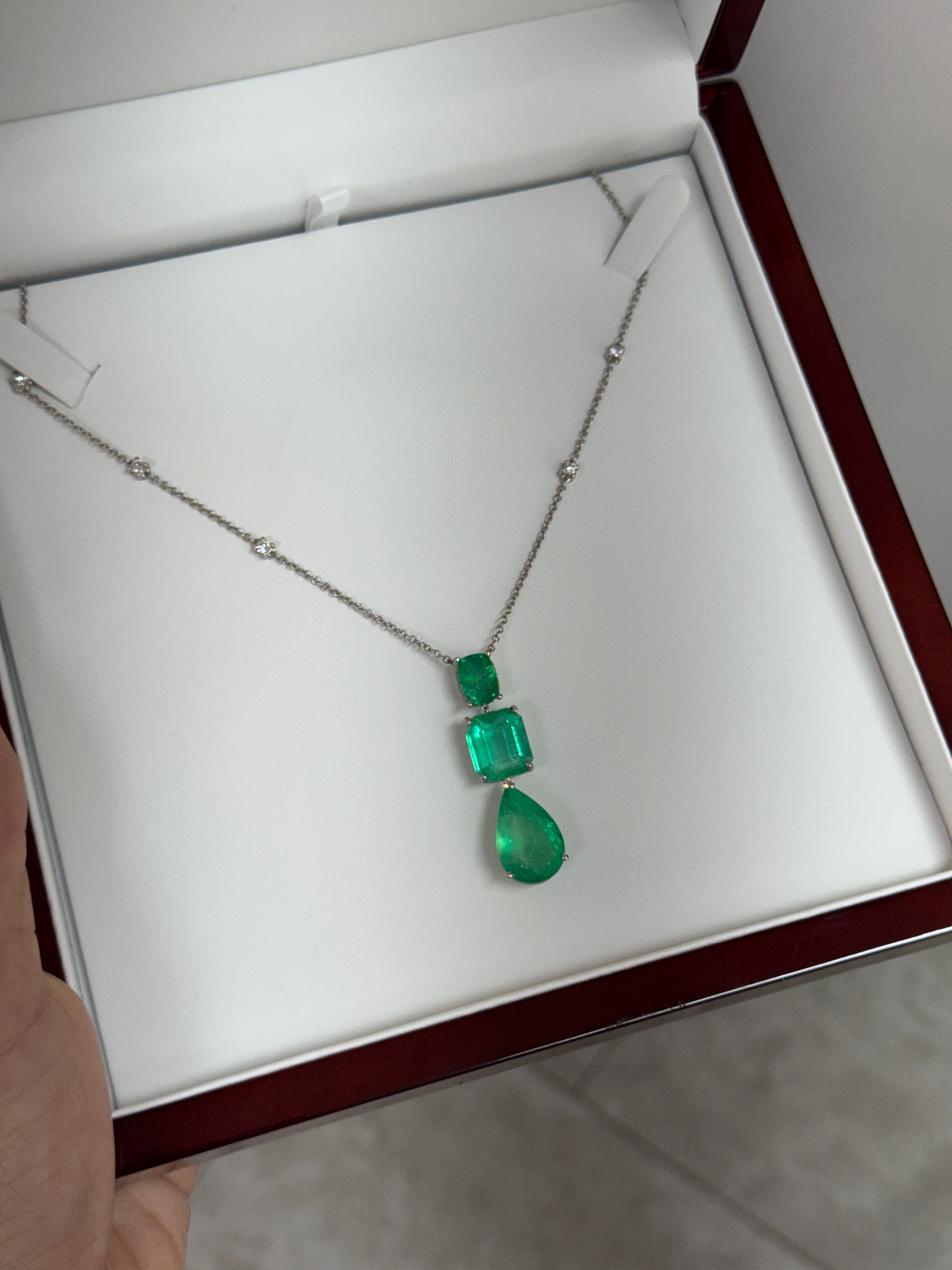 Colombian emerald and diamond by-the-yard necklace with cushion and pear-shaped emerald cuts in platinum, featuring 21.29tcw of gemstones.