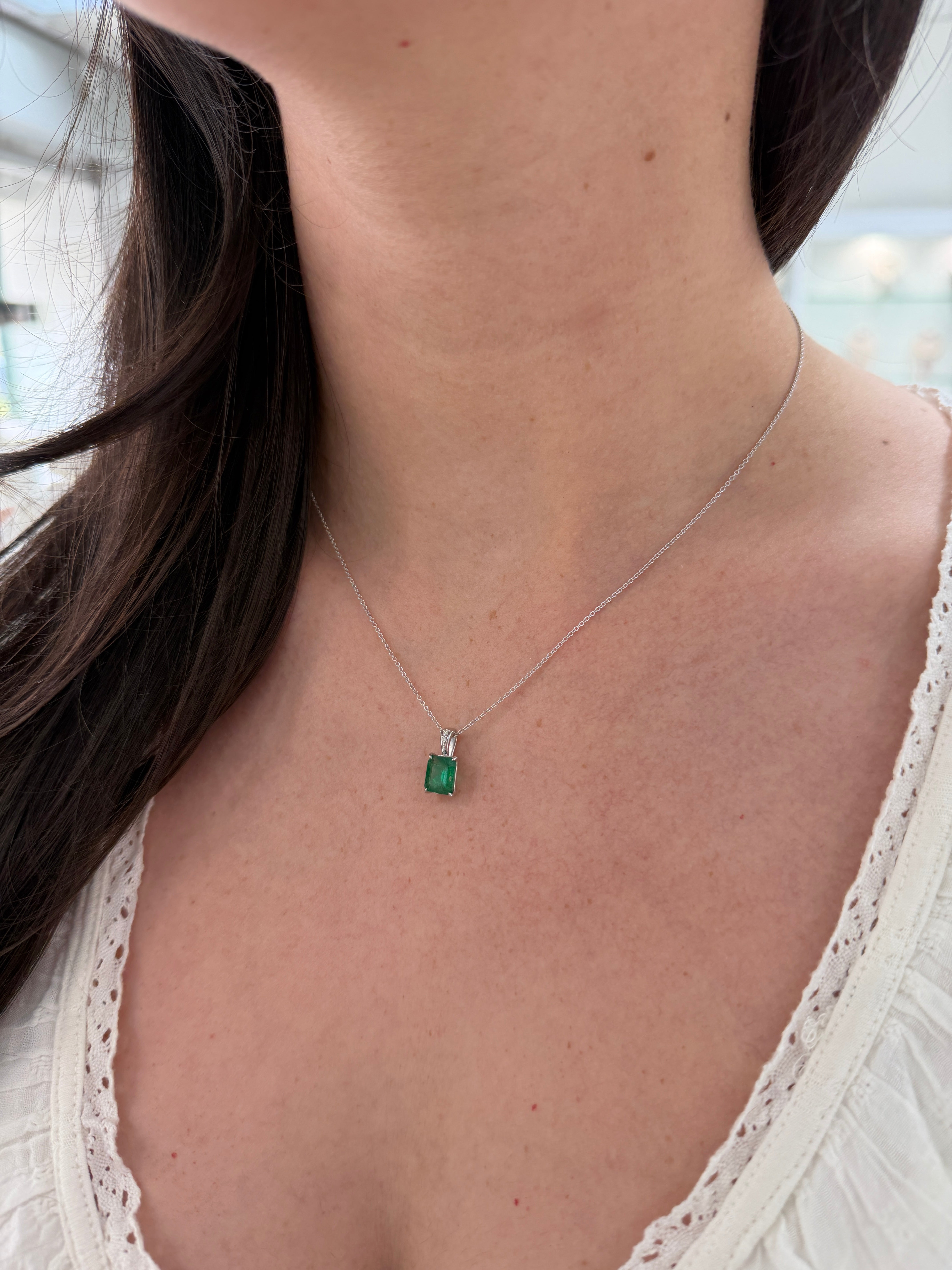 Emerald cut emerald and diamond bail pendant in 14K white gold with 1.60tcw, featuring a luxurious gemstone design.
