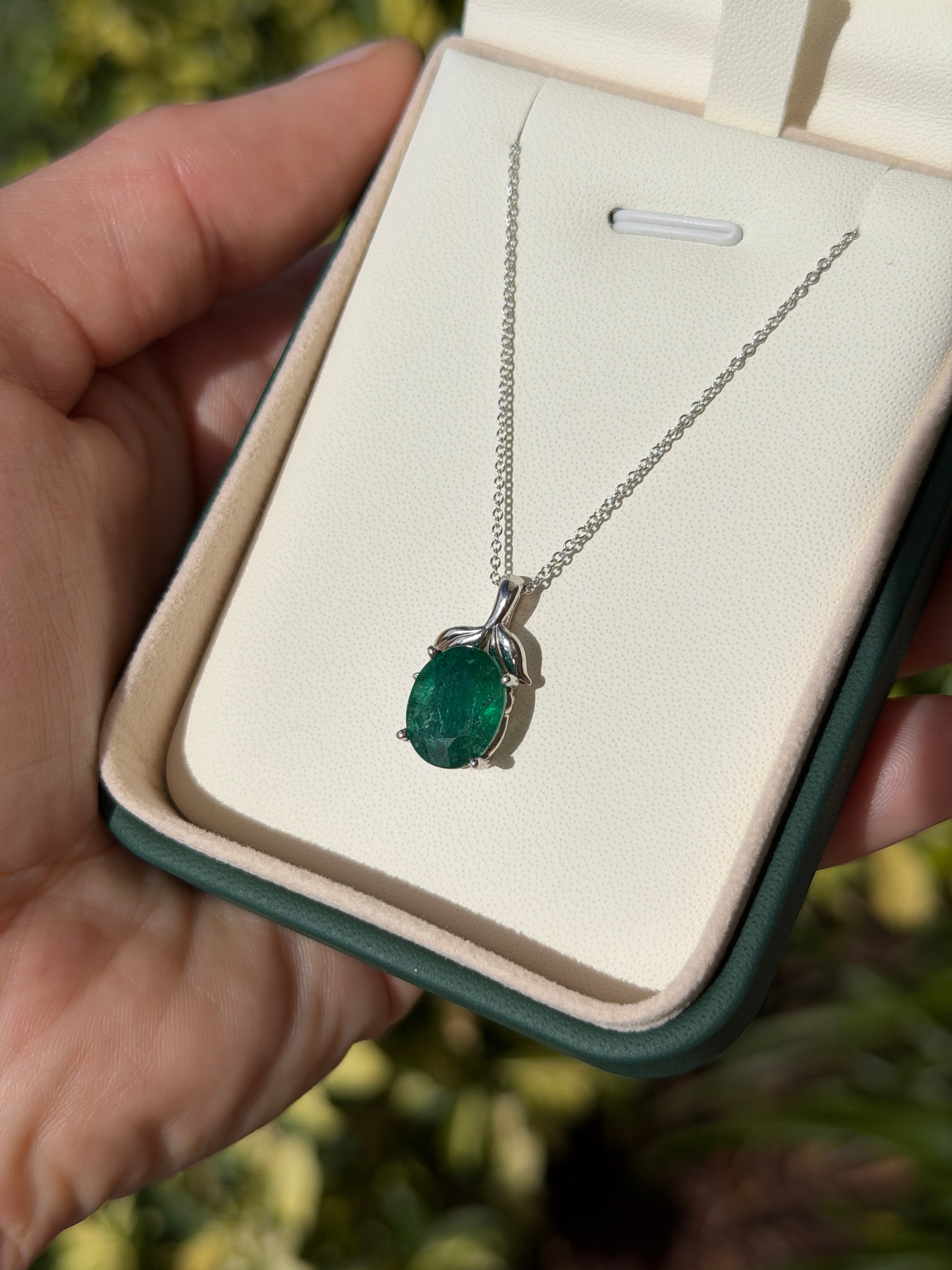 3.23 carat oval cut emerald pendant with leaf bail on platinum chain, nature-inspired design by JR Colombian Emeralds.