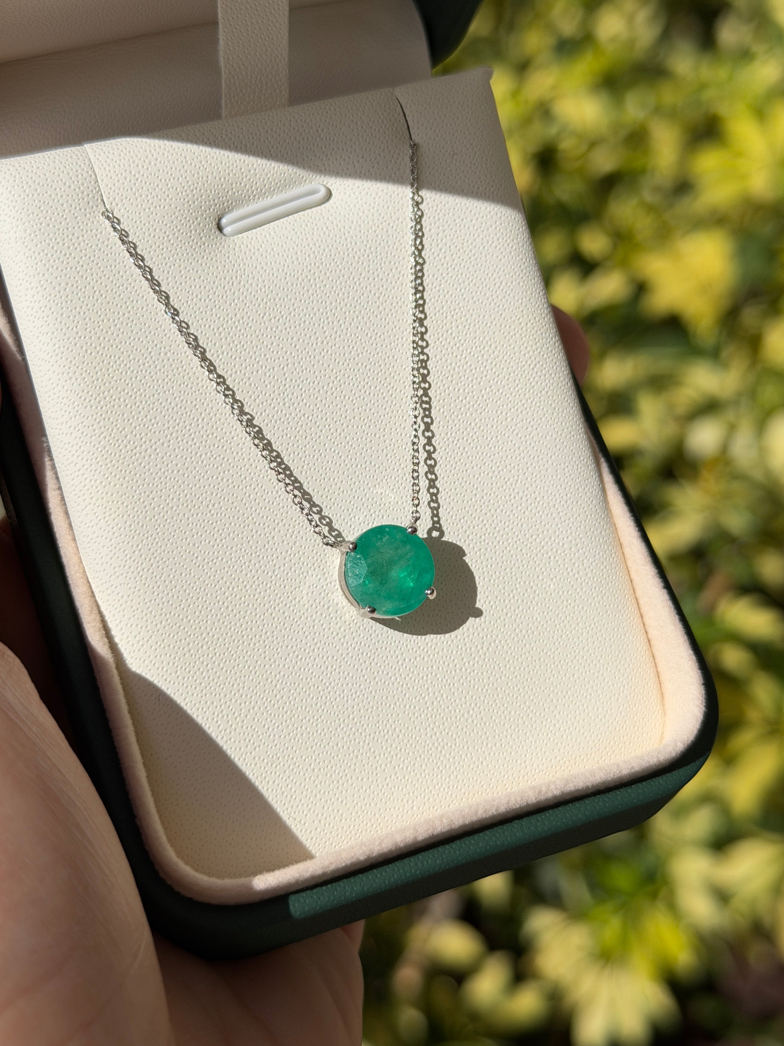 Natural round Colombian emeralds in an 18K gold stationary necklace by JR Colombian Emeralds, showcasing rich green hues.